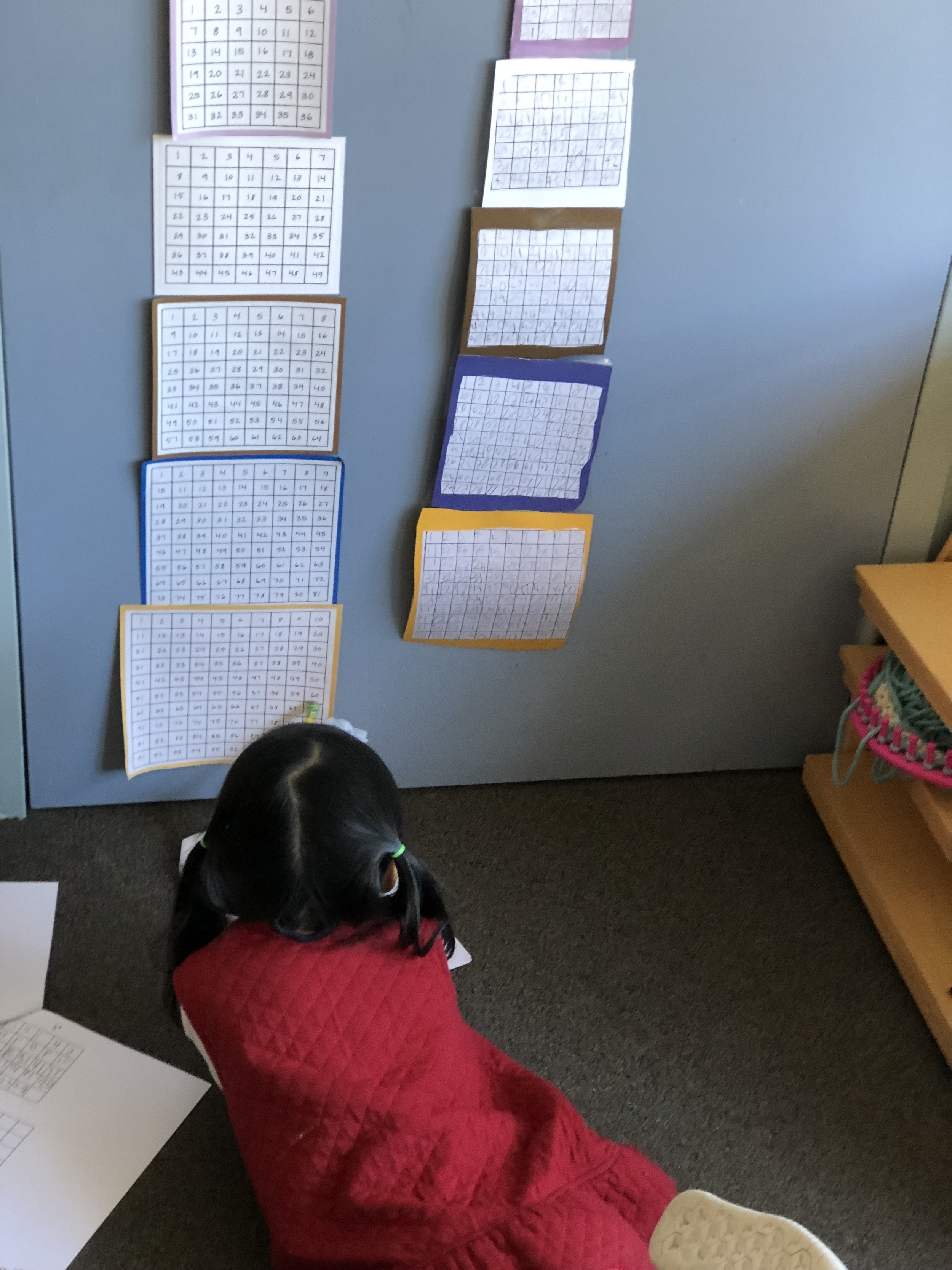  A child looking at a model while she works on her own Number Tower. 