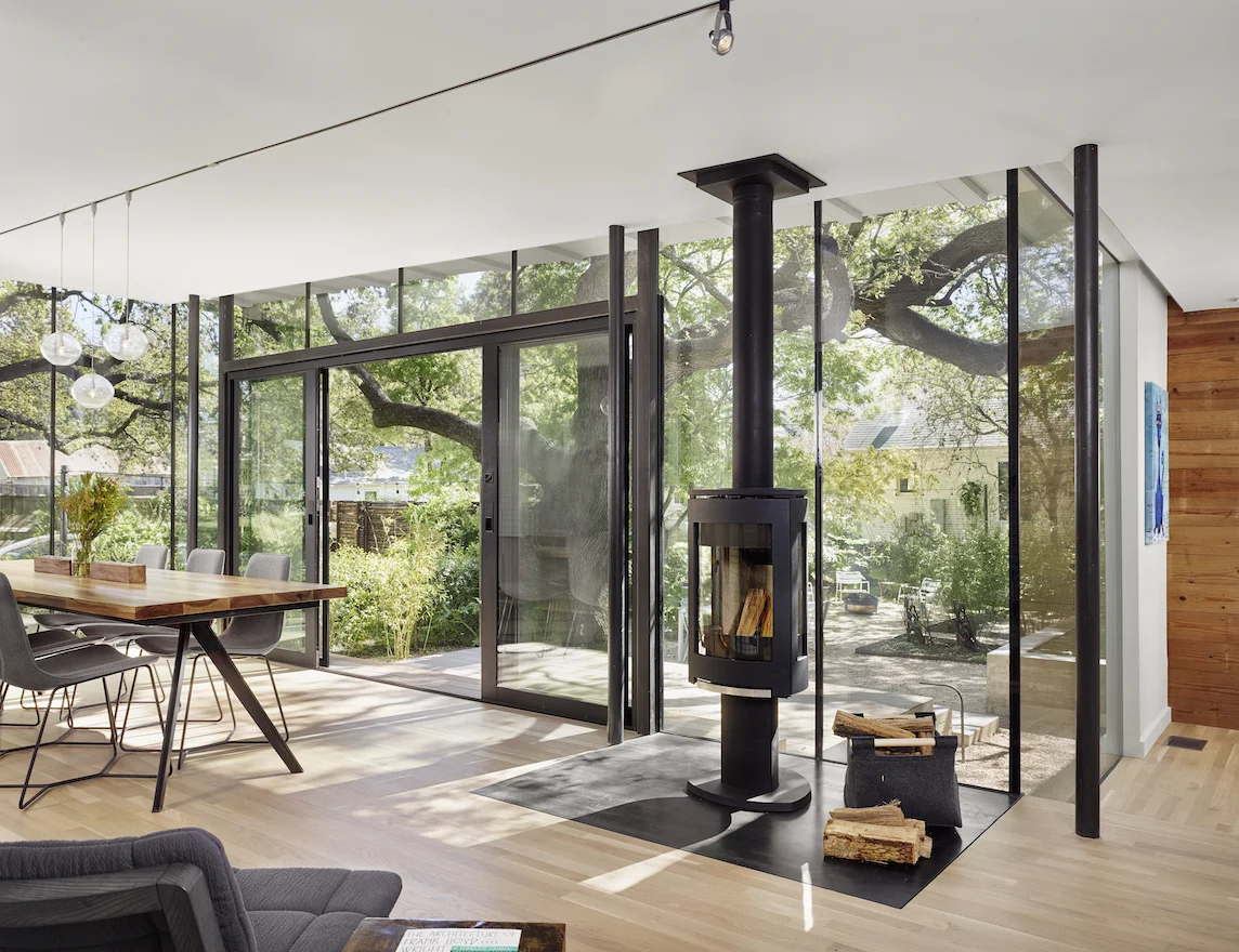 The new addition clad in reused galvanized metal is long and low in proportion, contrasting the slightly taller and more symmetrical older home with its clean white teardrop siding.
