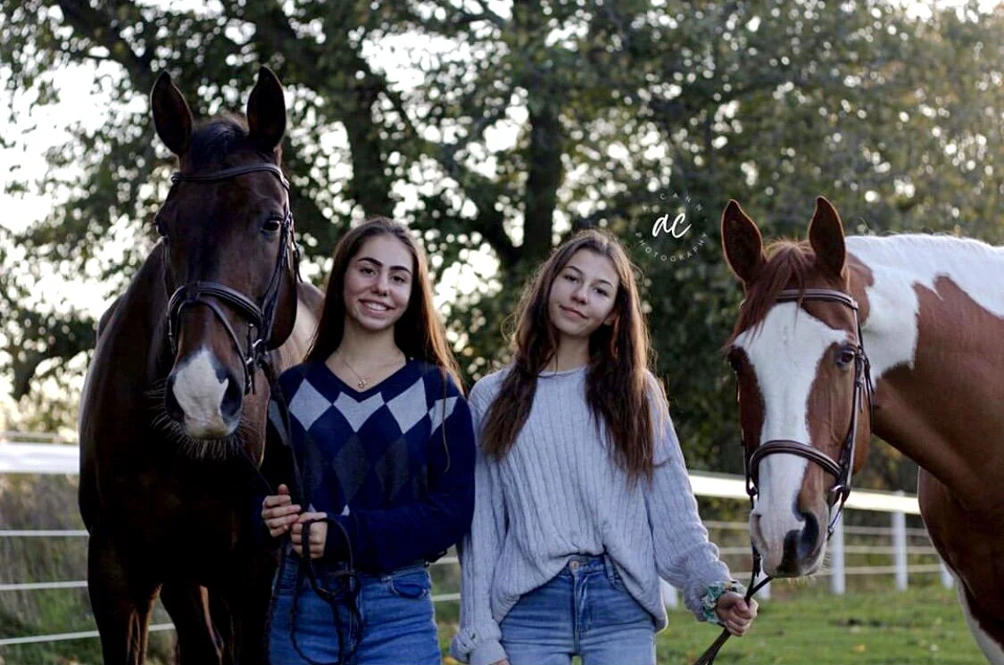 Young Pickering Horse Centre students smiling and holding their horses outside