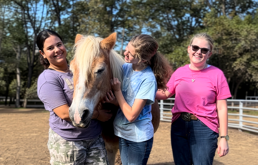 Girls smiling with a horse