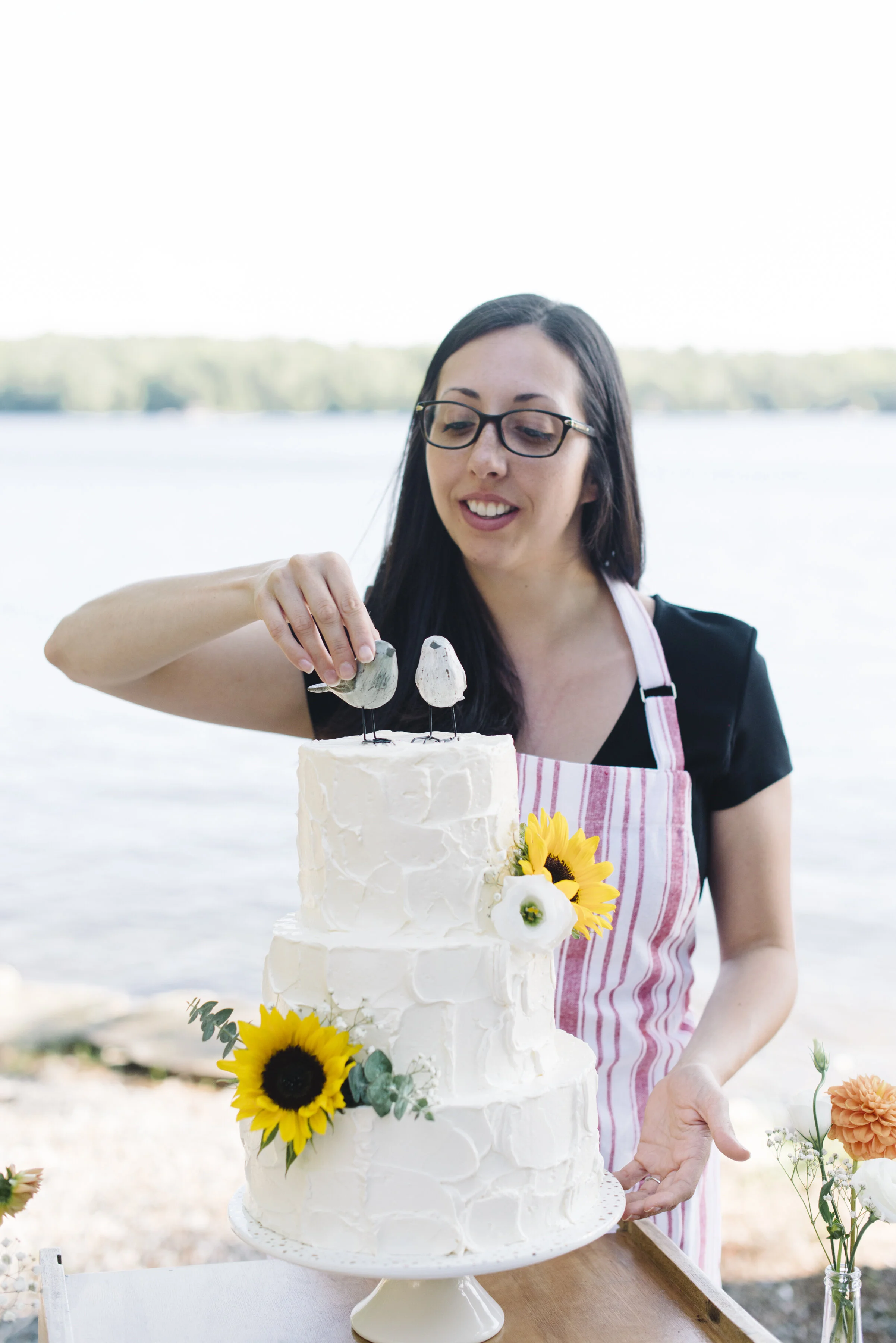 Branding lifestyle photo of Happiness is Sweet preparing a wedding cake, captured for a small business commercial photography session in Toronto