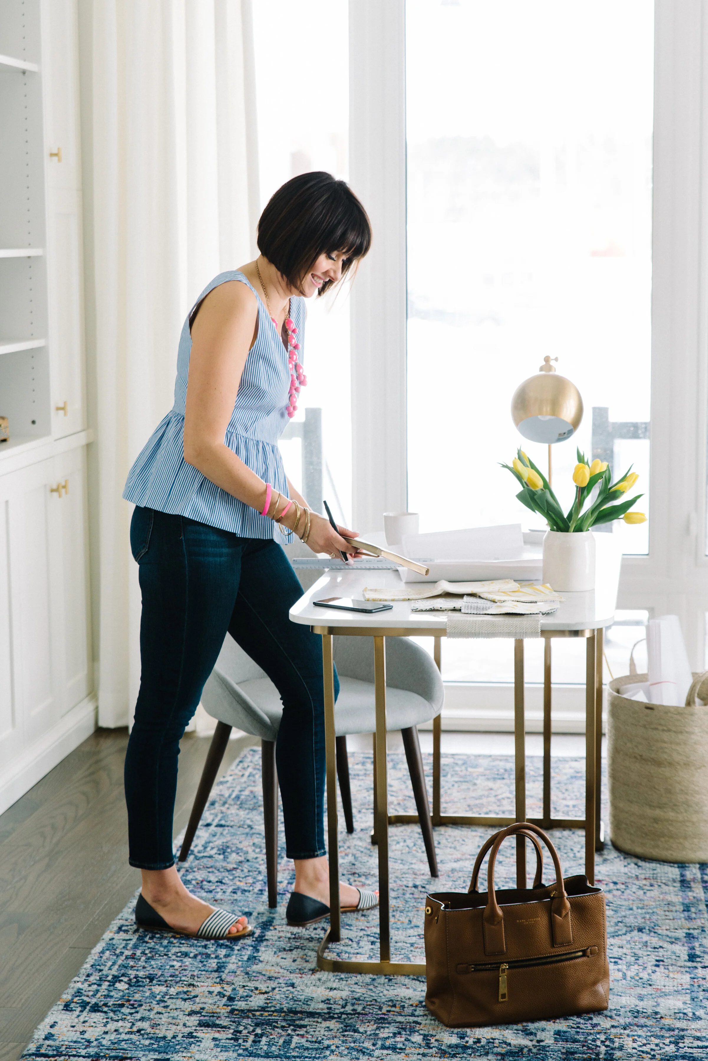 Lifestyle branding portrait of Rebecca Hay standing at a desk working in a beautifully designed interior space in Toronto