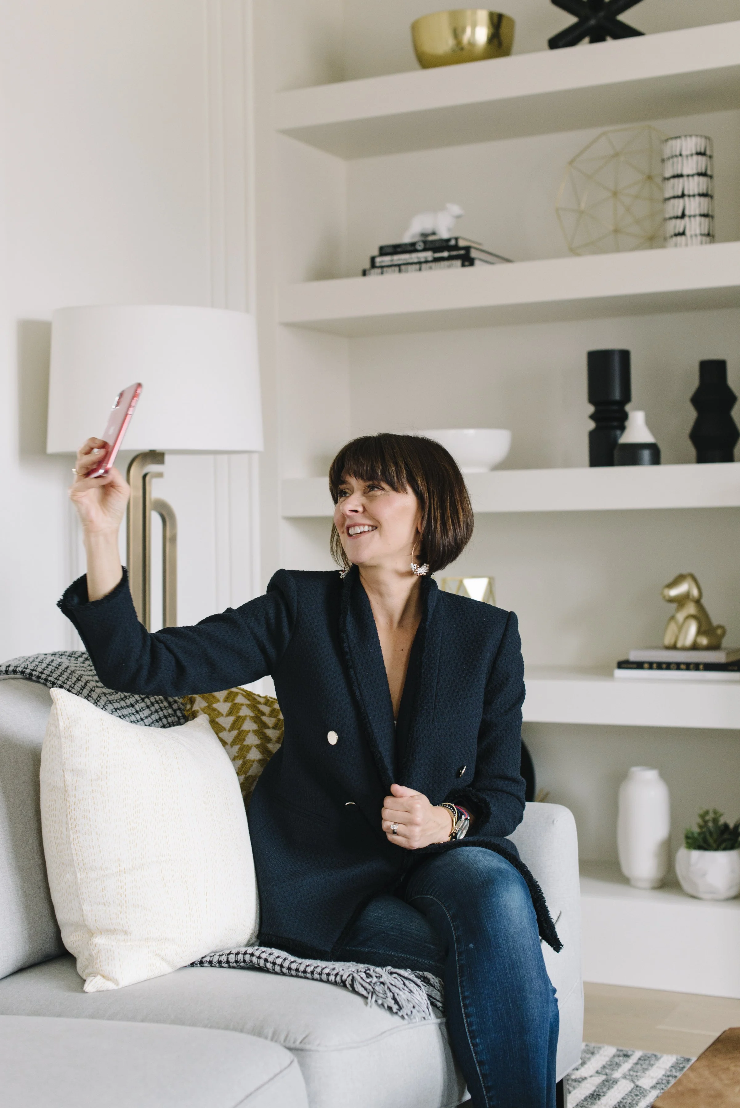 Candid lifestyle branding photo of Rebecca Hay seated on a couch taking a selfie