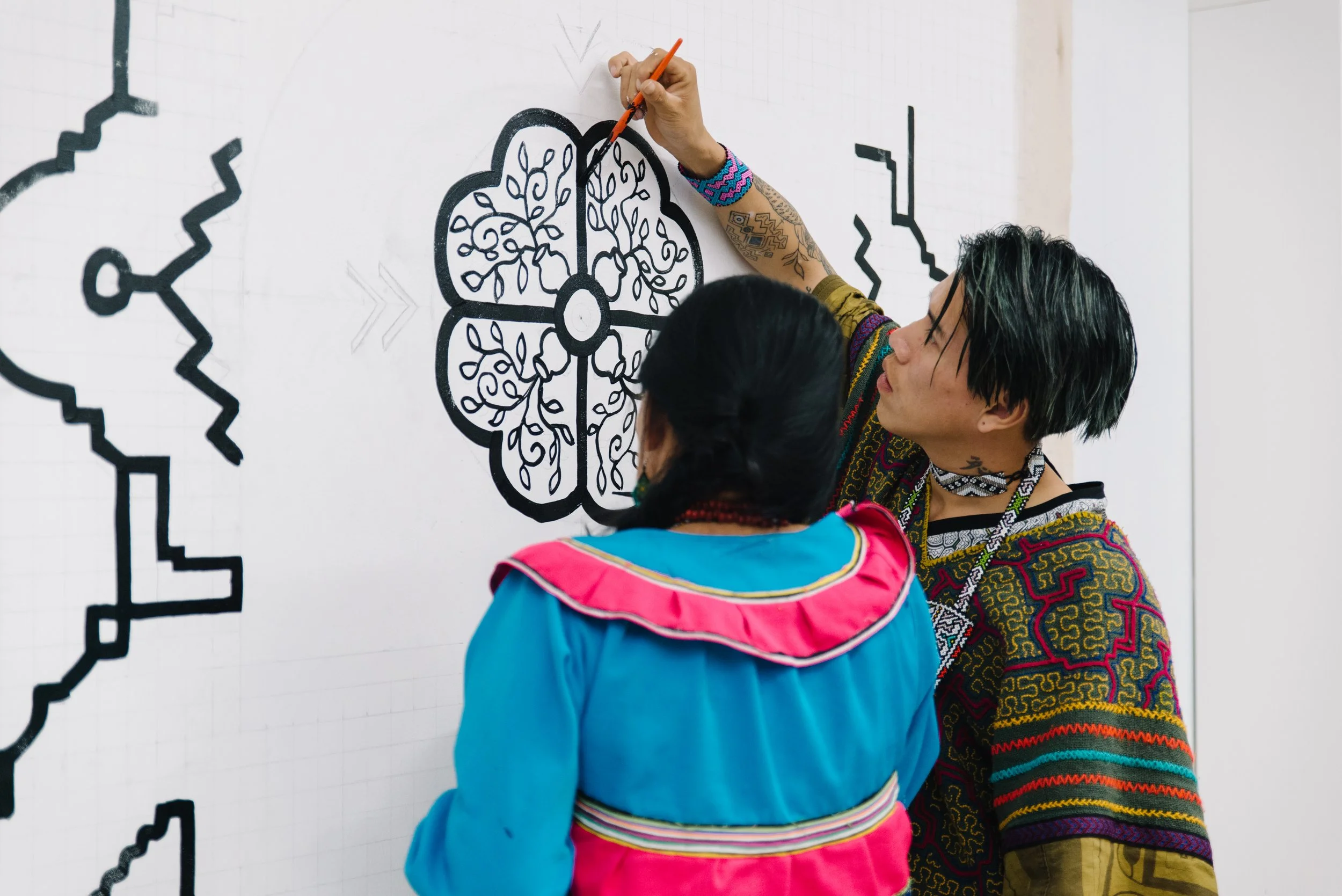Close documentary portrait of Olinda Reshinjabe Silvano and her team working together on the nearly completed Paisajes de Nosotros mural at TMU