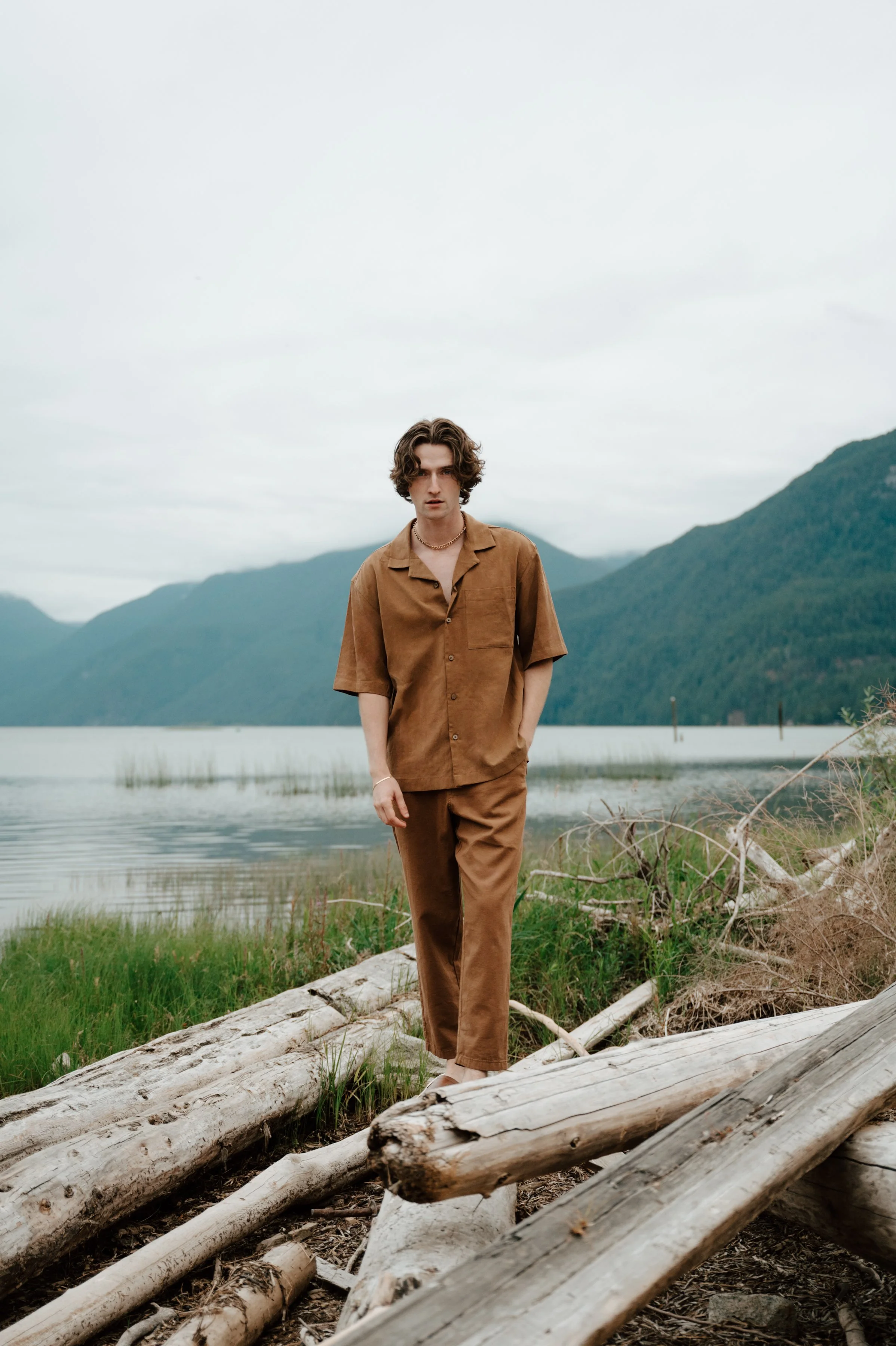 Fashion forward environmental portrait of model Callum Campbell with mountainous landscape in the background