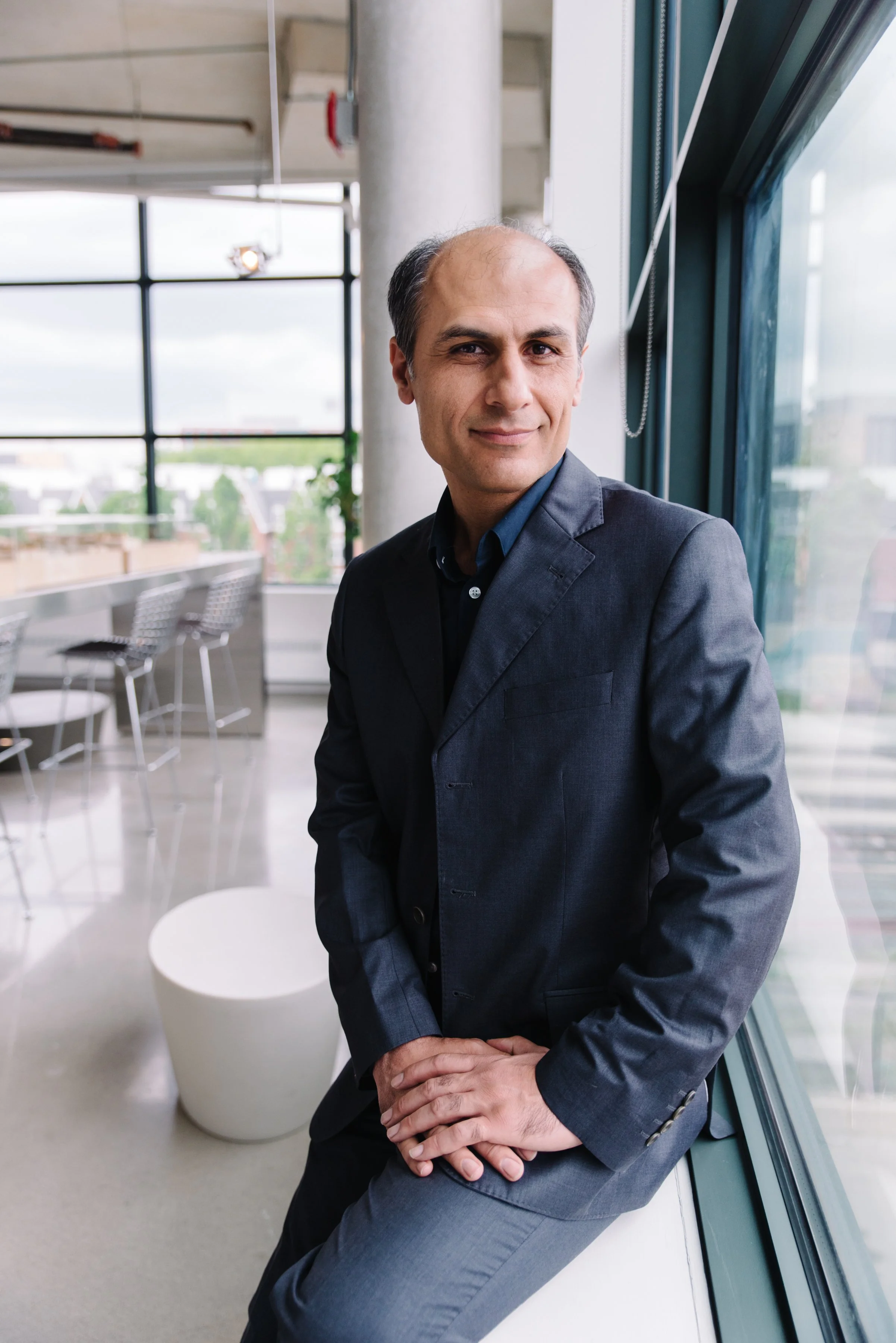 Approachable corporate headshot of a Kasian staff member in a design-focused workspace