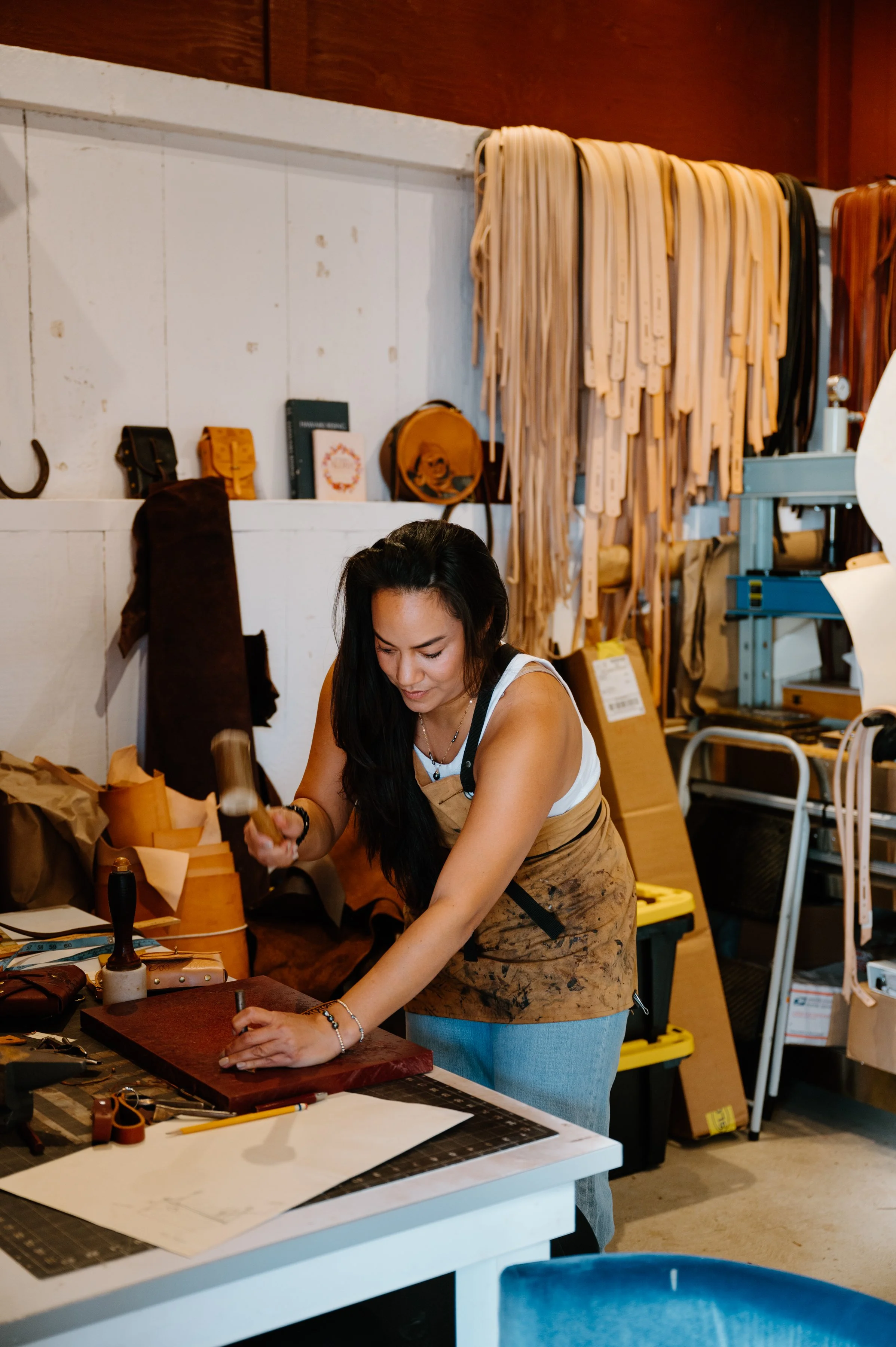 Taira Barron Cran working in her leather studio for Salty Western in Waimea, Hawaiʻi