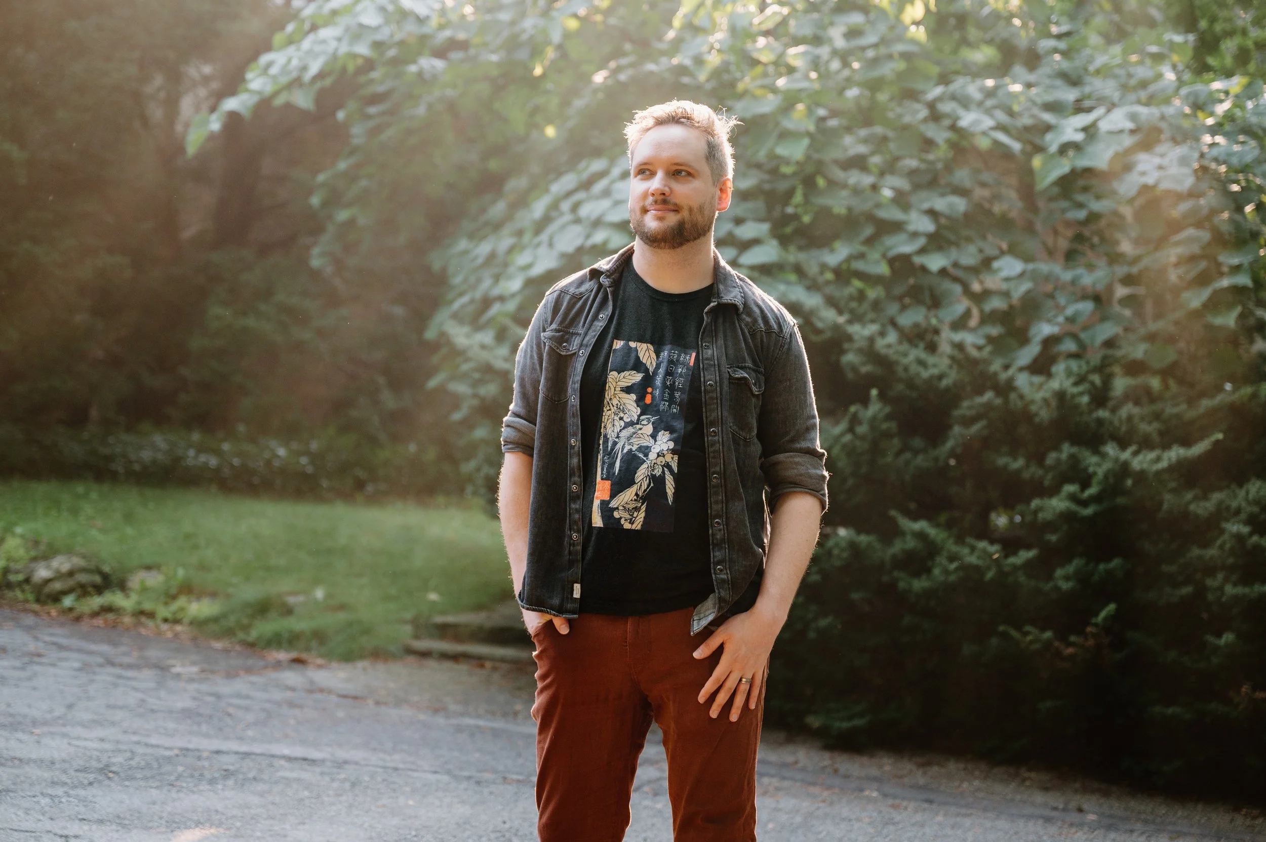 Lifestyle portrait of a man walking through Wychwood Barns with warm sunlight beaming directly behind him in Toronto