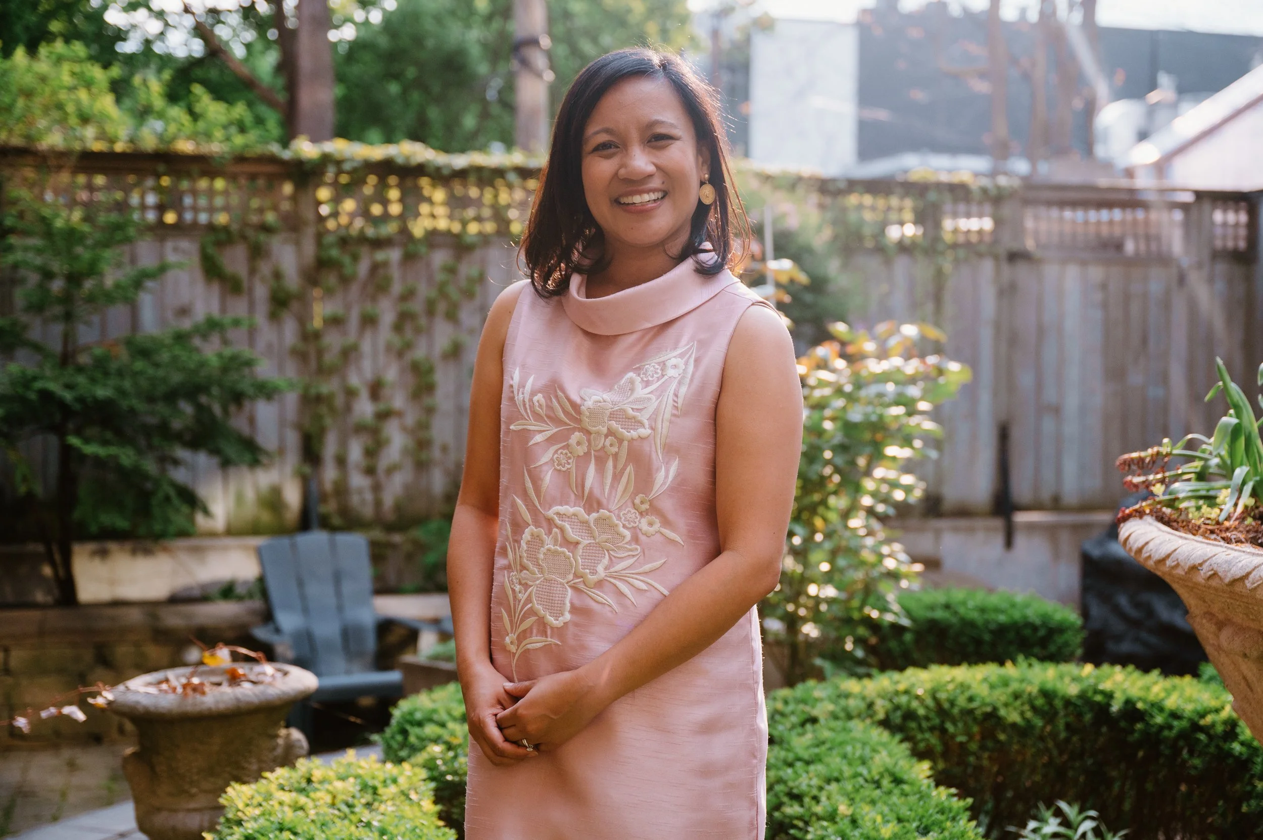 Lifestyle portrait of Filipino-Canadian author Jennilee Austria-Bonifacio in traditional dress at golden hour in a Toronto garden