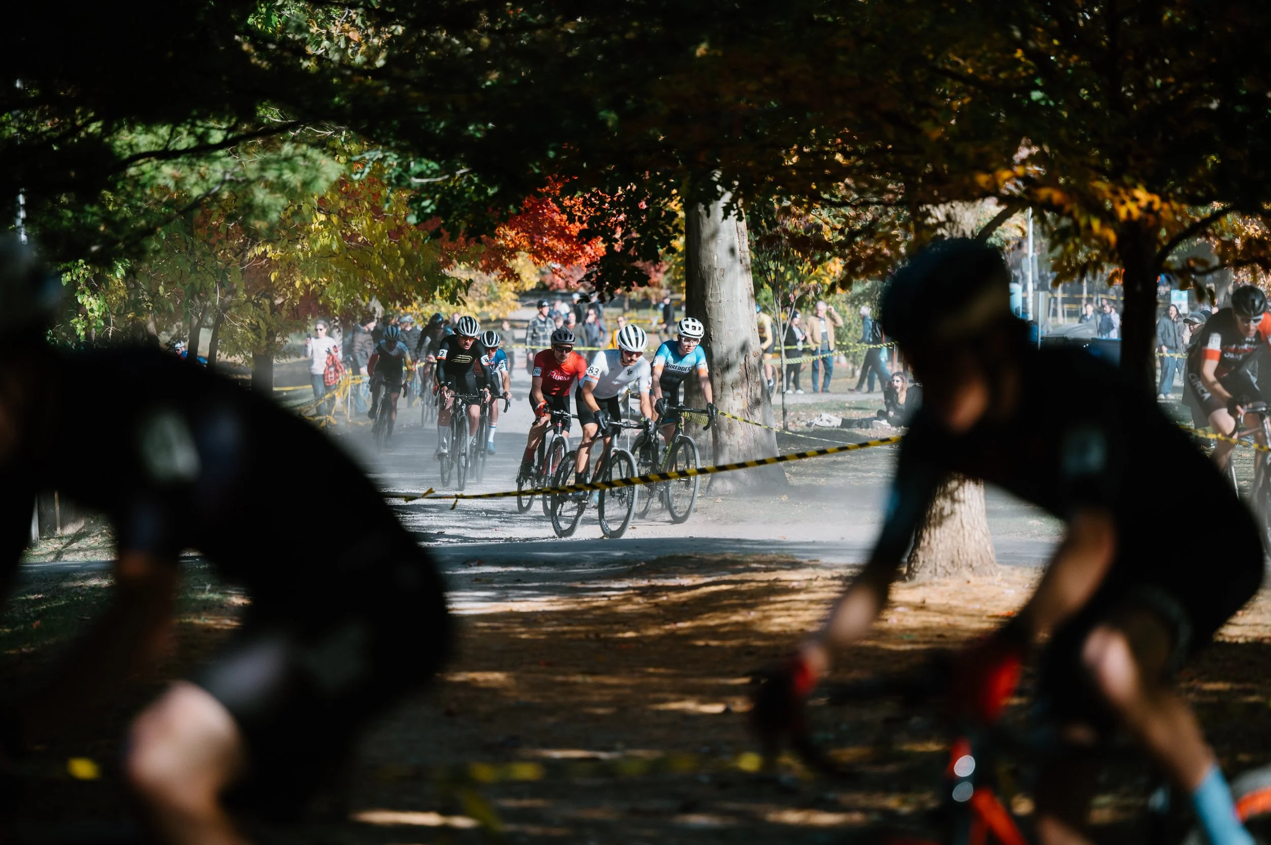 Large group of cyclocross riders moving through the flat sections of Christie Pits Park in Toronto