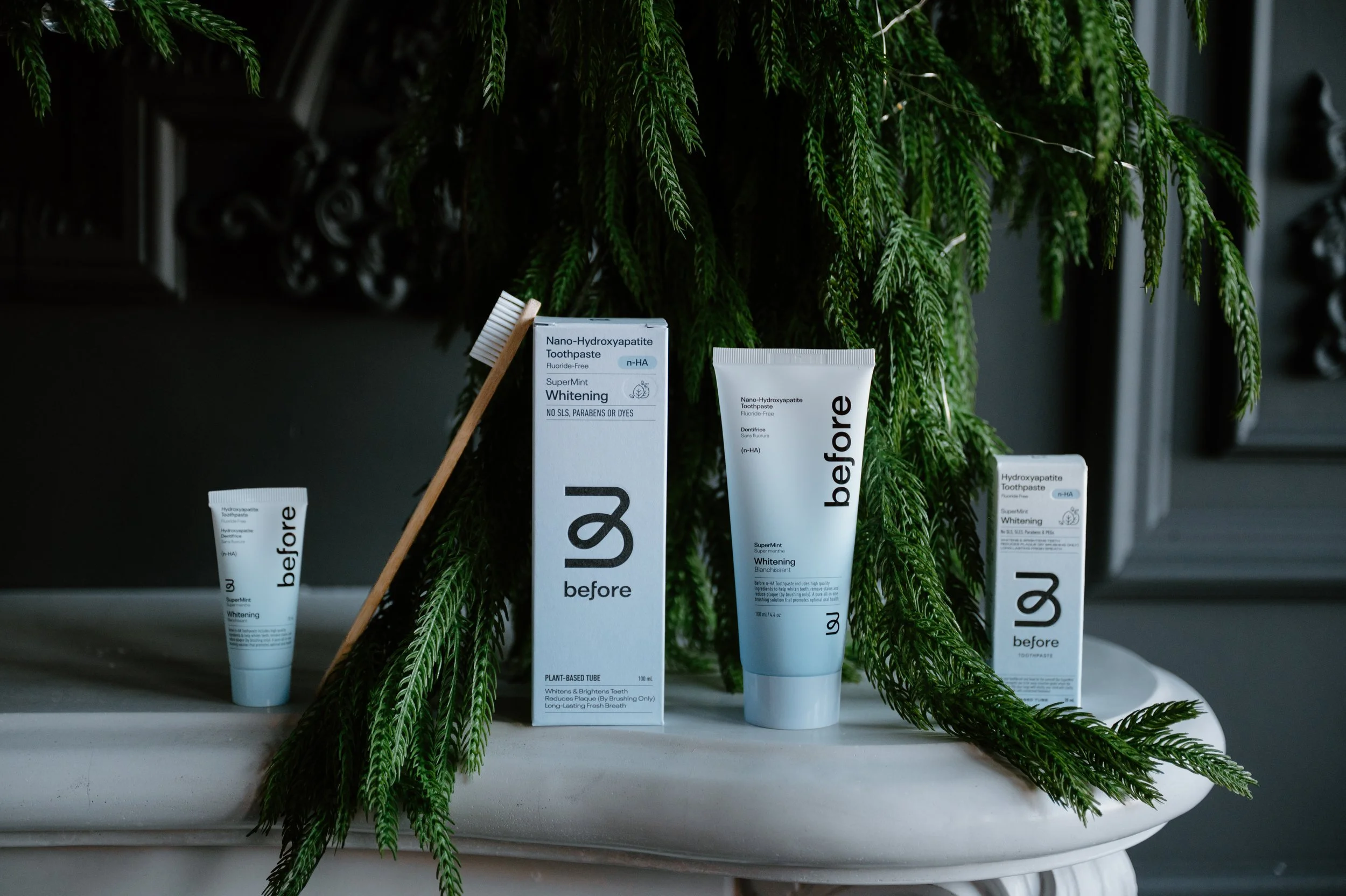 Toothpastes and toothbrush displayed on a mantle with garland