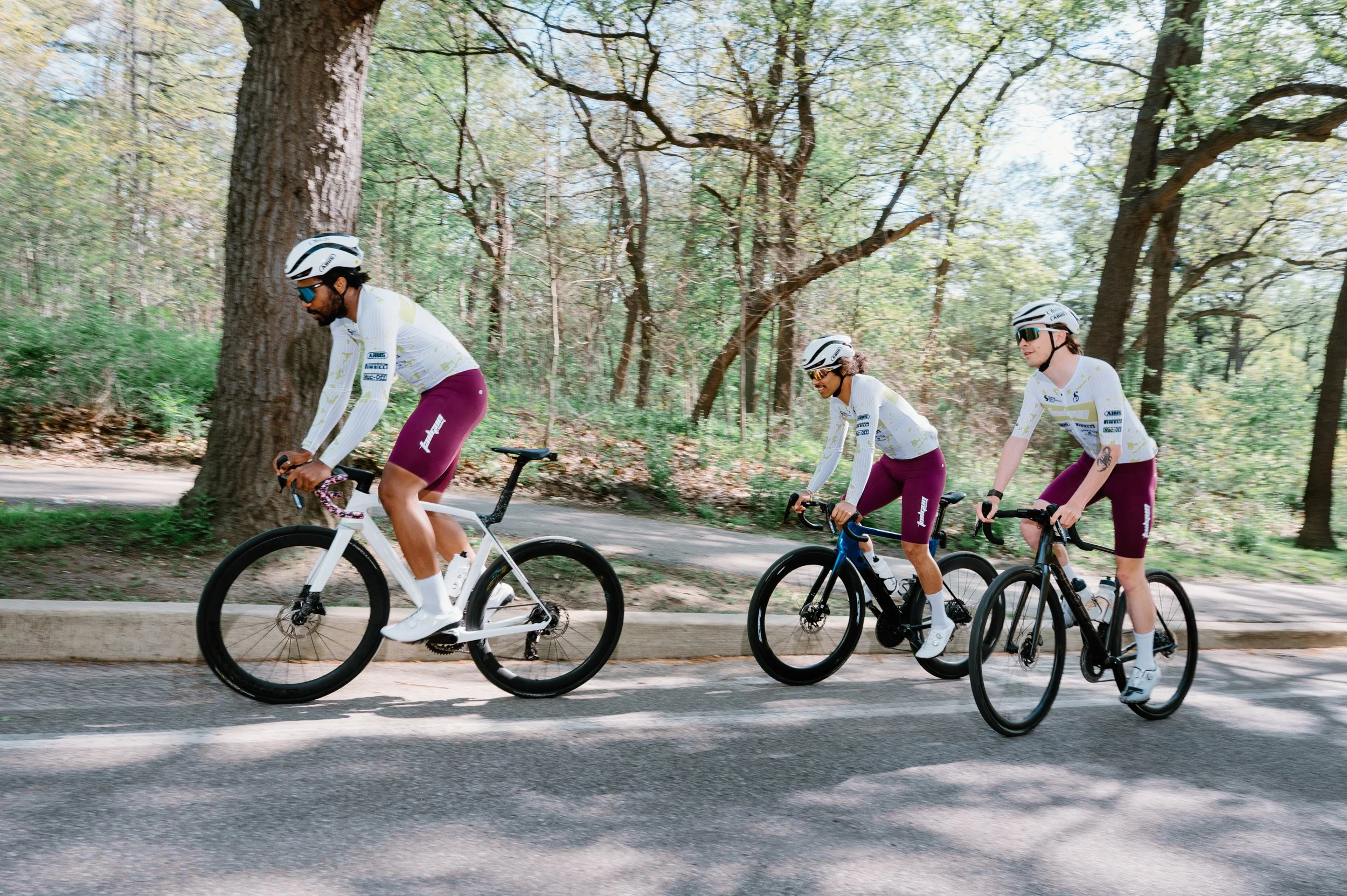 Three road cyclists climbing a hill together in motion at High Park, Toronto, captured for a cycling campaign