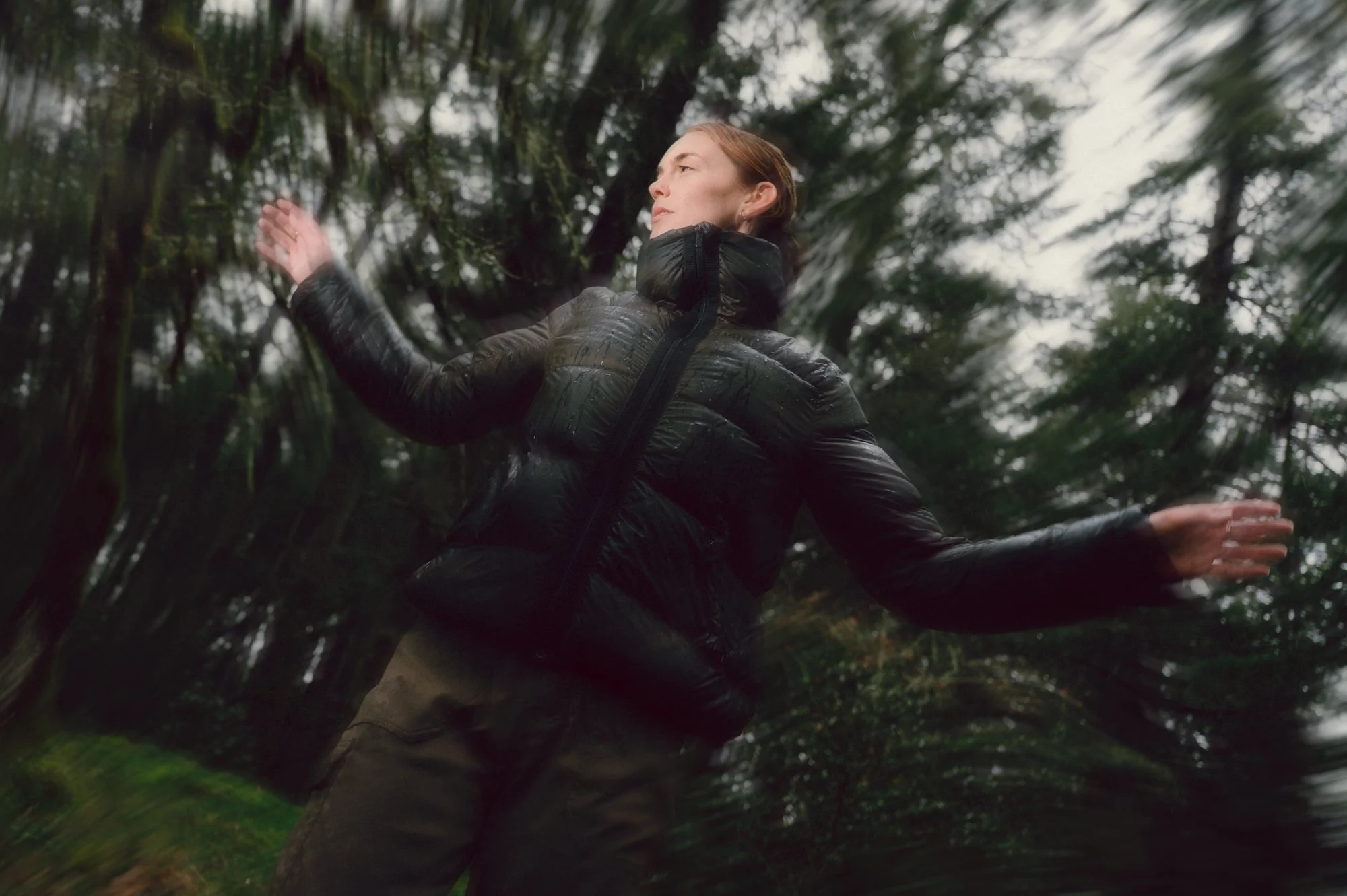 Editorial lifestyle photo of a model in motion with intentional blur, captured among the mossy forest of Vancouver Island
