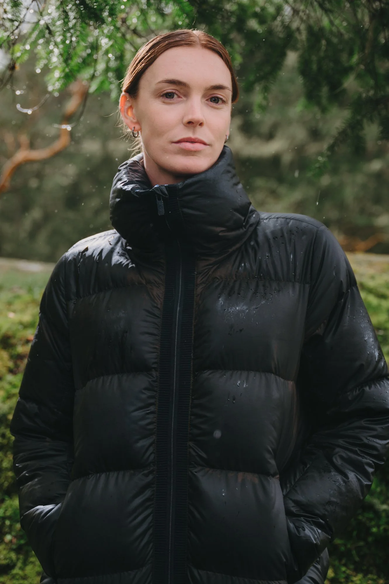 Close commercial portrait of a Stranger Agency model in an Arc'teryx-style puffer jacket, photographed in the misty forests of Vancouver Island