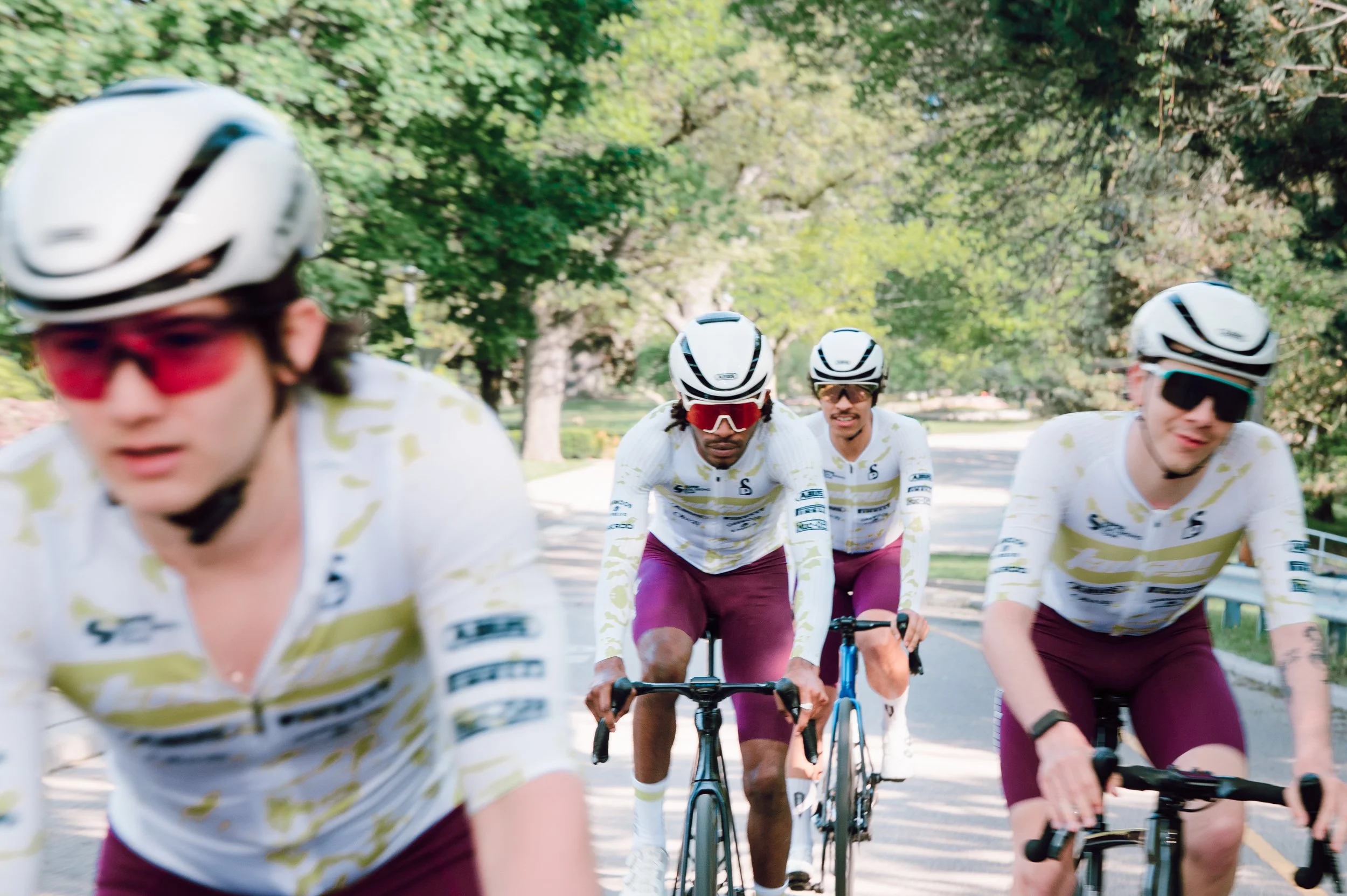 Commercial photography of a road cycling team riding directly toward the camera in High Park, Toronto