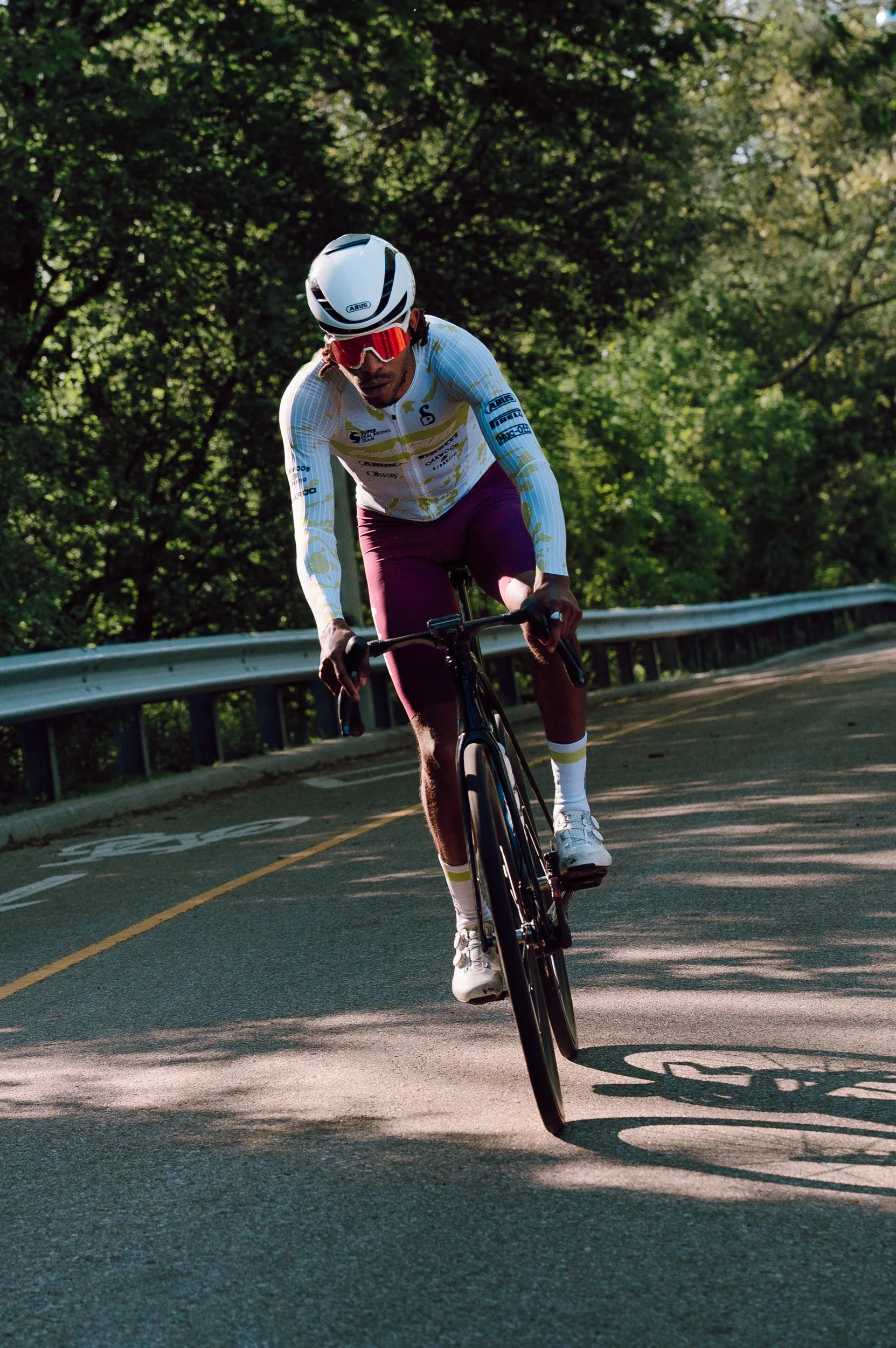 Dramatic light portrait of a single road cyclist in High Park, Toronto, suited for cycling brand or apparel campaign photography