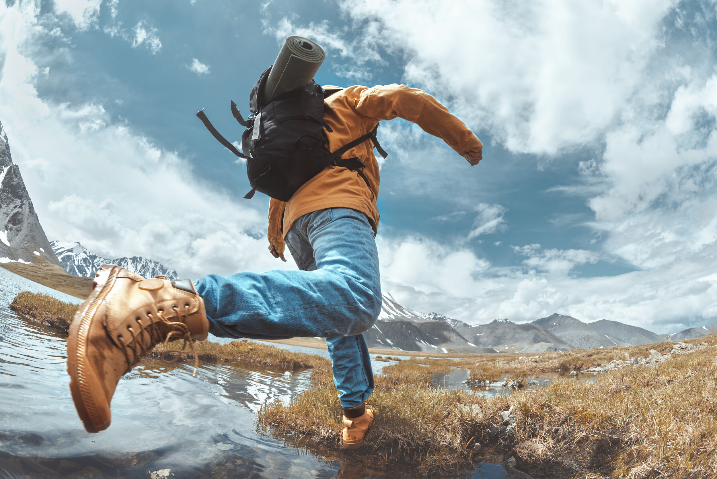 bigstock-Hiker-Jumps-Across-Water-In-Mo-285695158.jpg