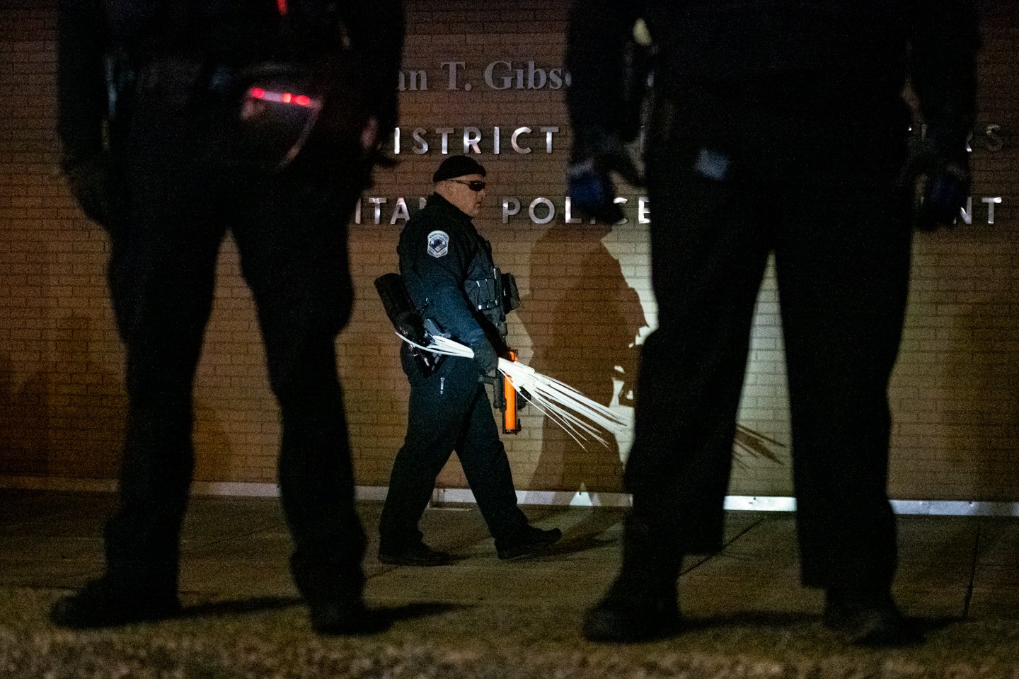  A police officer carries zip-tie restraints and multiple “less-lethal” weapons during a protest demanding justice for Karon Hylton-Brown, outside the MPD Fourth District Headquarters, in Washington, D.C., on December 19, 2020. (Photo by Graeme Sloan