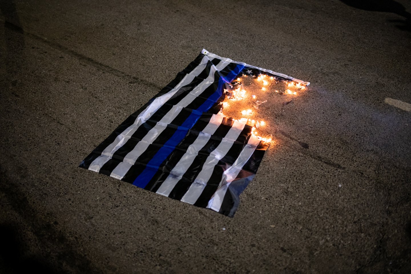  A blue lives matter flag burns on the ground during a protest demanding justice for Karon Hylton-Brown, outside the MPD Fourth District Headquarters, in Washington, D.C., on December 19, 2020. (Photo by Graeme Sloan) 