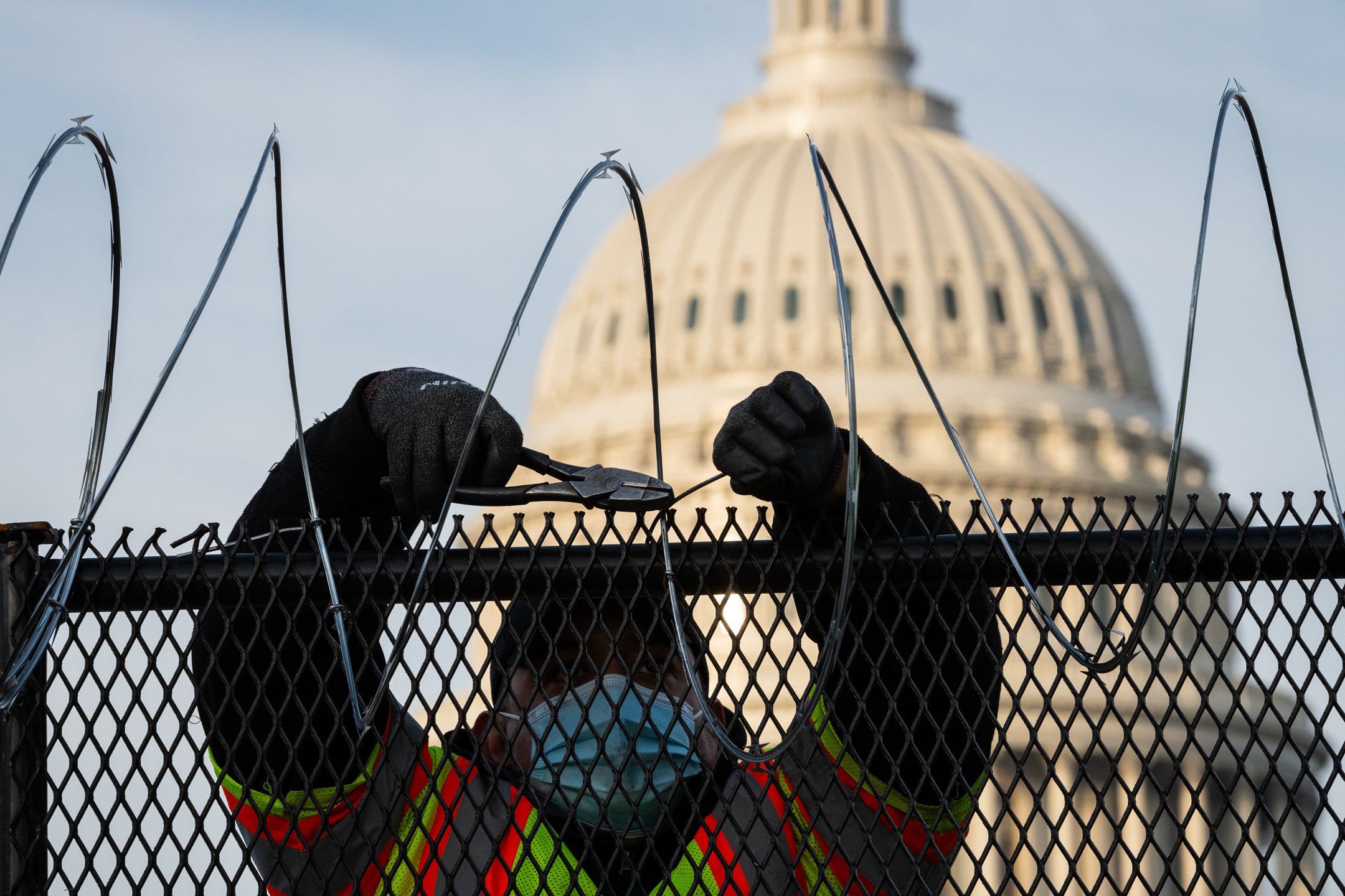  A worker installs razor wire on security fencing near the U.S. Capitol ahead of Presidential Inauguration day, in Washington, D.C., on January 15, 2021. (Graeme Sloan for Sipa USA) 