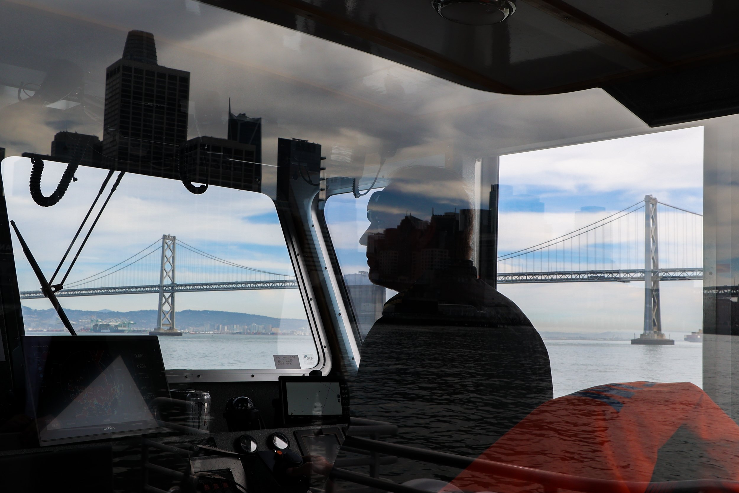  Captain Jeremiah Brazil pilots the Treasure Island ferry through the Bay on March 1, 2022.  “This is my office,” Brazil said, gesturing to the waves under the Bay Bridge. “I just love this job.” 