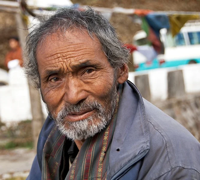 Nomadic farmers take their yaks to high altitudes during the summer and bring them to lower altitudes during the winter. This farmer is selling yak cheese and yak butter on the roadside by Cheli La Pass.
