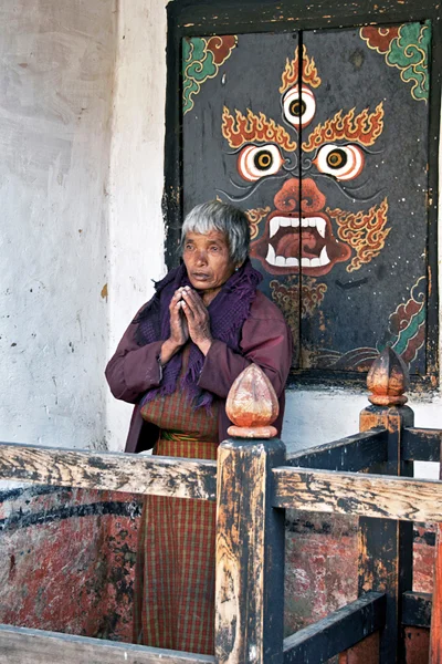 A local woman prays in Jampey Lhakhang temple believed to have been built in 659 A.D. by a Tibetan king in order to subdue a female Tibetan demon.