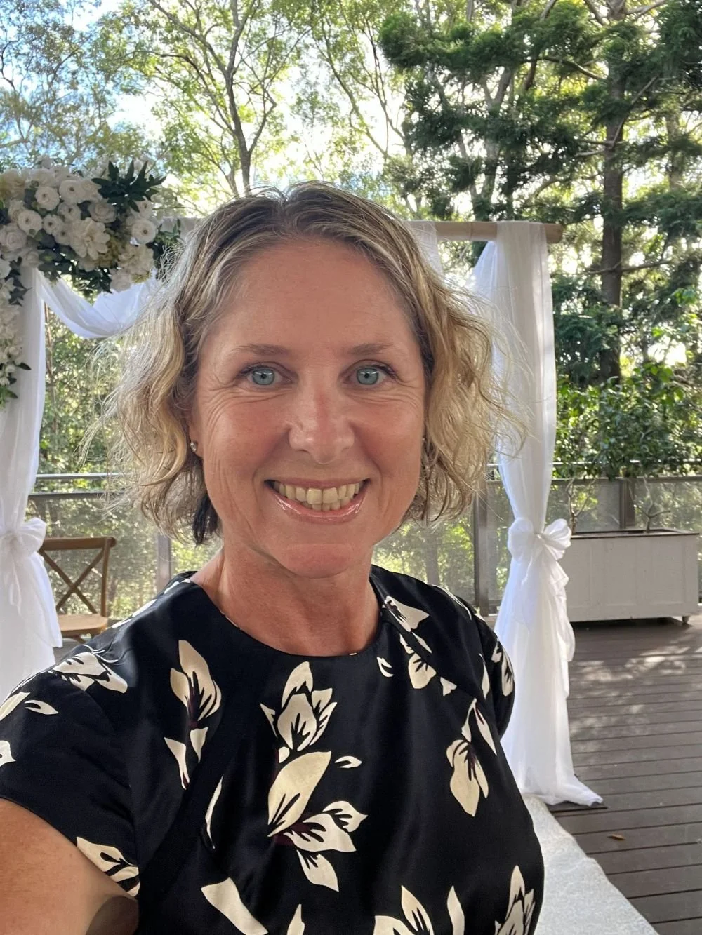 Trudy the Celebrant in front of wedding arbour on the Walkabout Creek Wedding Venue The Deck