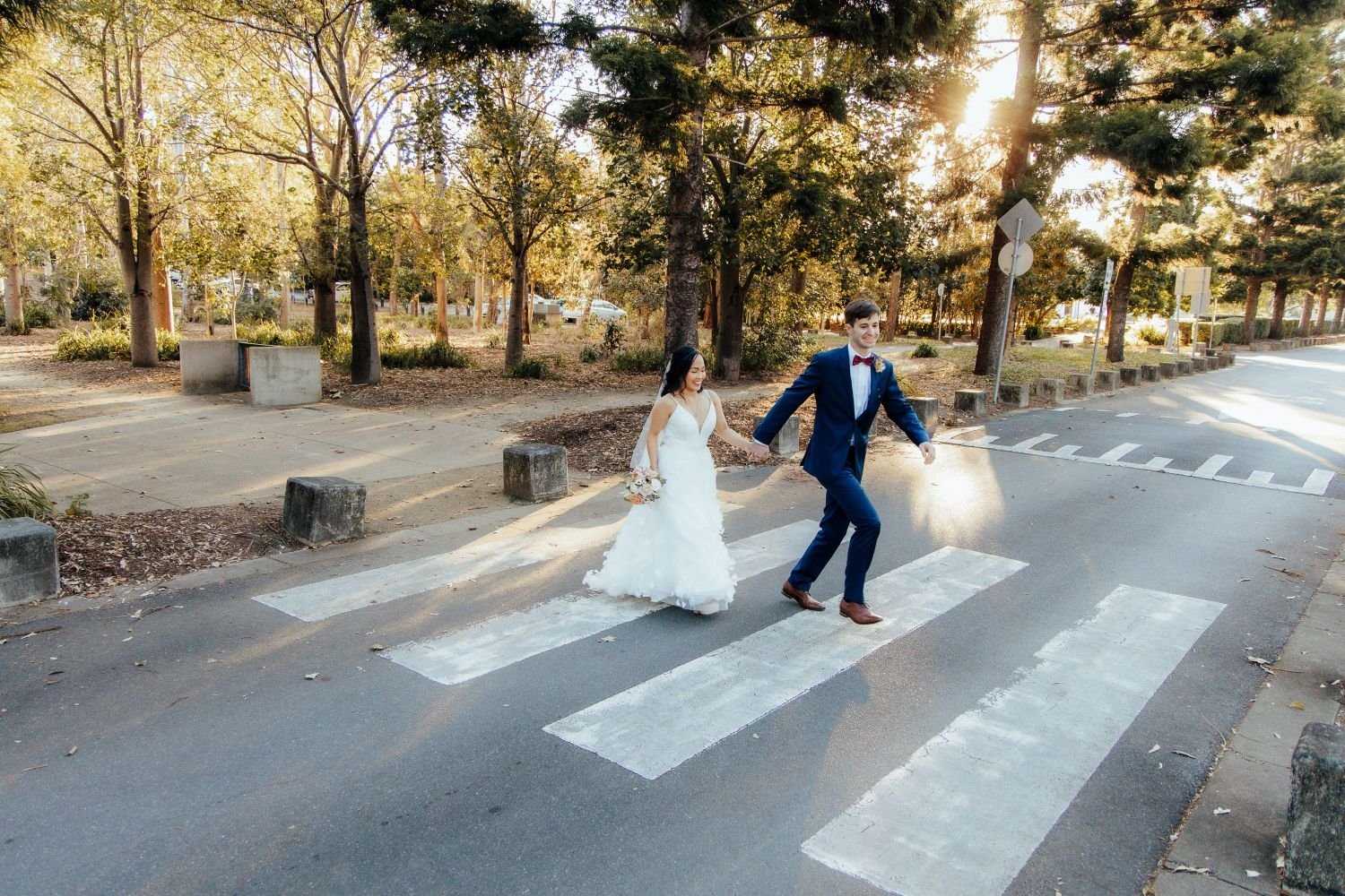 Just married couple walking across a pedestrian crossing in a park Brisbane Park Wedding_Trudy the Celebrant