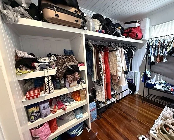 Overflowing walk-in wardrobe with crowded shelves before a wardrobe audit