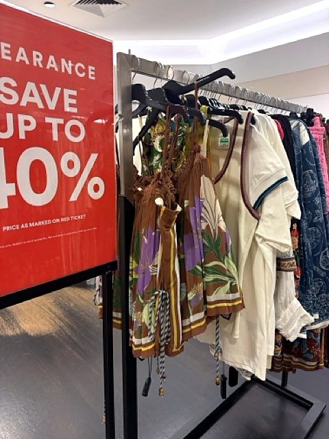 Clearance sale rack with printed clothes, a reminder to shop with intent