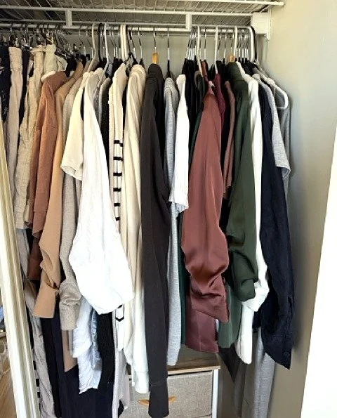 Tidy hanging rail of neutral clothes in an organised wardrobe after a wardrobe audit