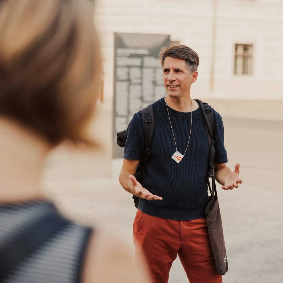 Male tour guide engaged with group on a neighbourhood walk in Hietzing, Vienna, telling stories of world famous artists like Egon Schiele and Gustav Klimt