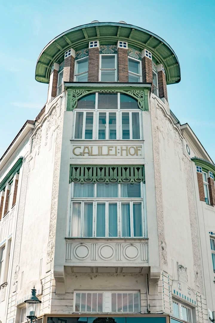 Corner of an Art Nouveau building called the Galileo Hof, topped with a semi-circular structure and a rounded roof section in green, Hietzing, Vienna