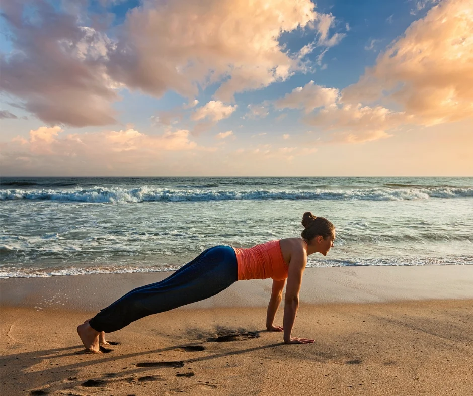 Woman doing plank on the beach as part of the core circuit.