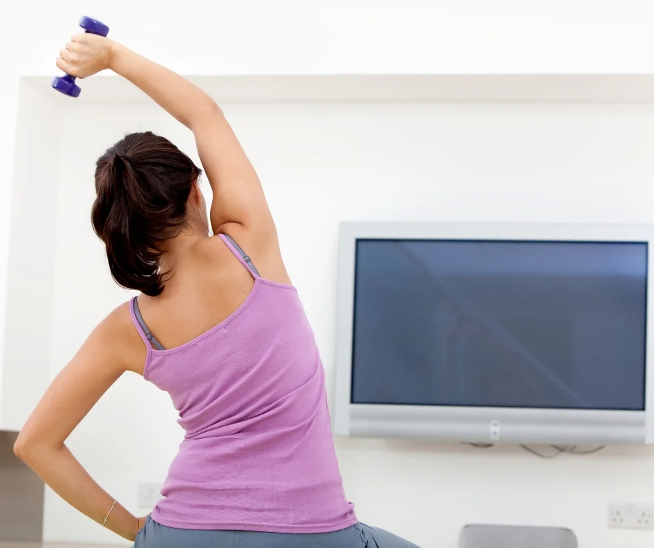 Woman uses exercise ball for at home workout.