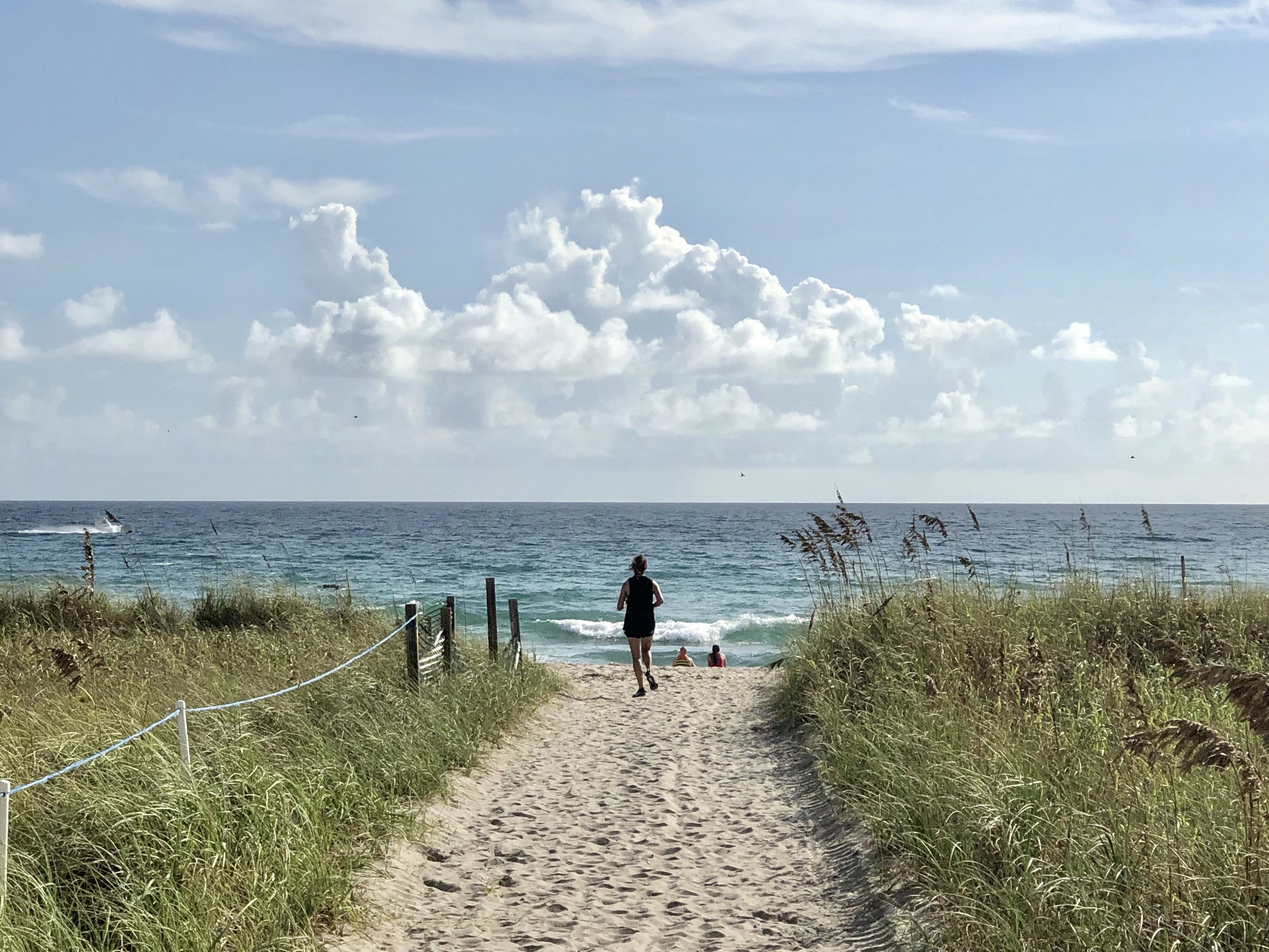 Girl running on beach during her fitness retreat.
