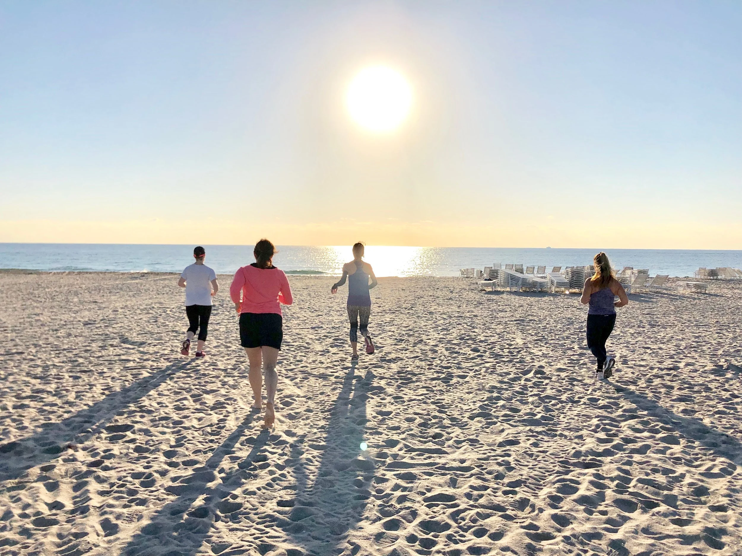 Ladies running during a fitness class on the beach in Delray Beach, FL.