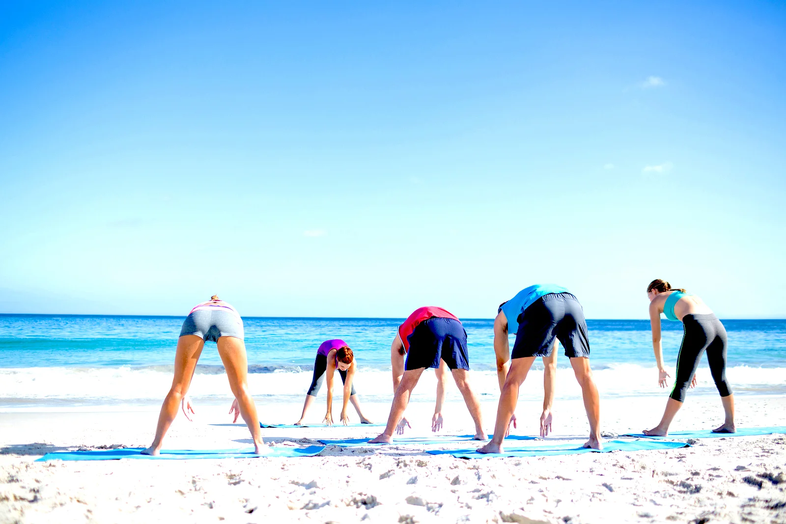 Guests stretching on the beach at Vita Vie Retreat.