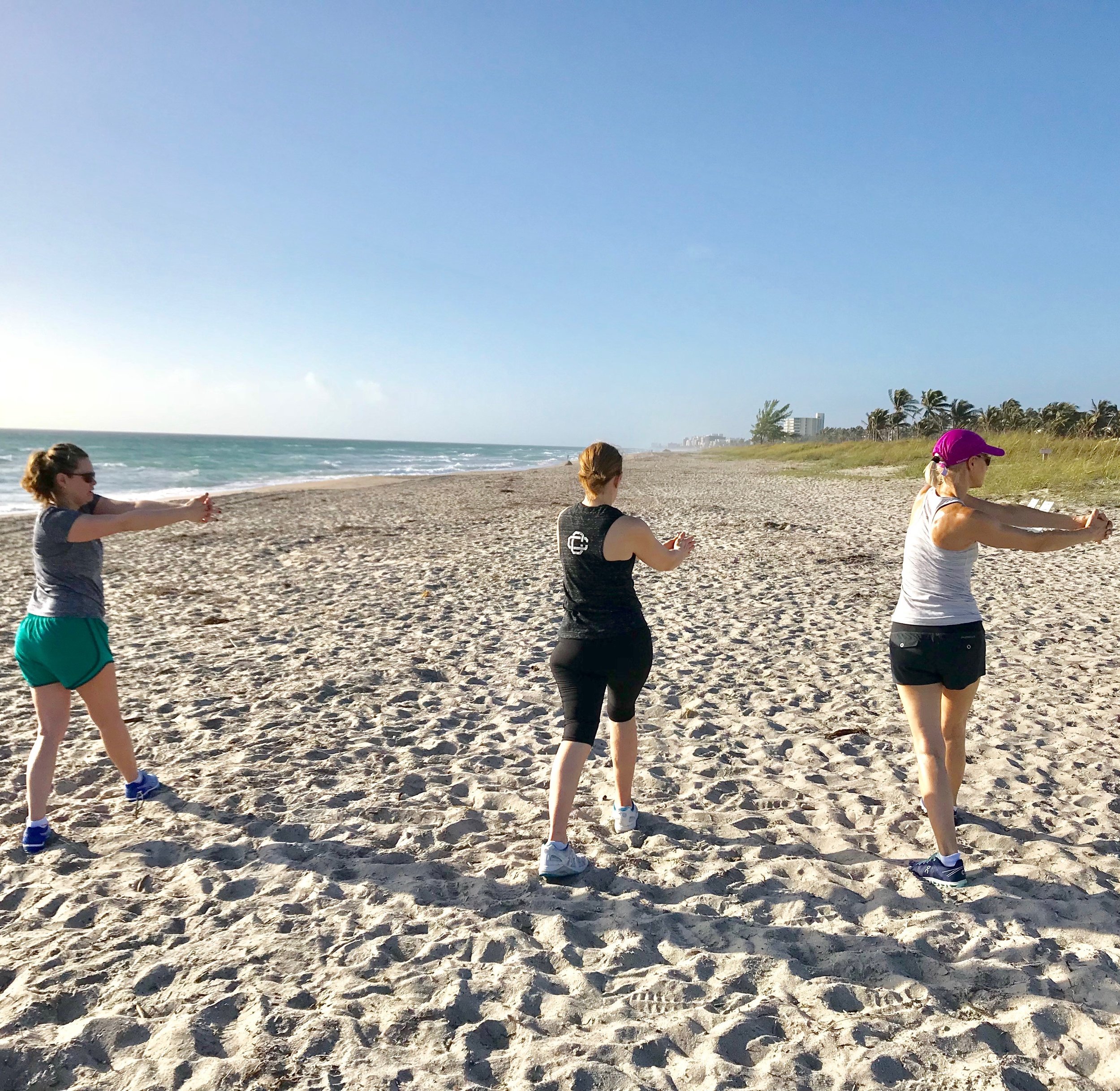 Guests begin the morning at the beach with dynamic stretch.