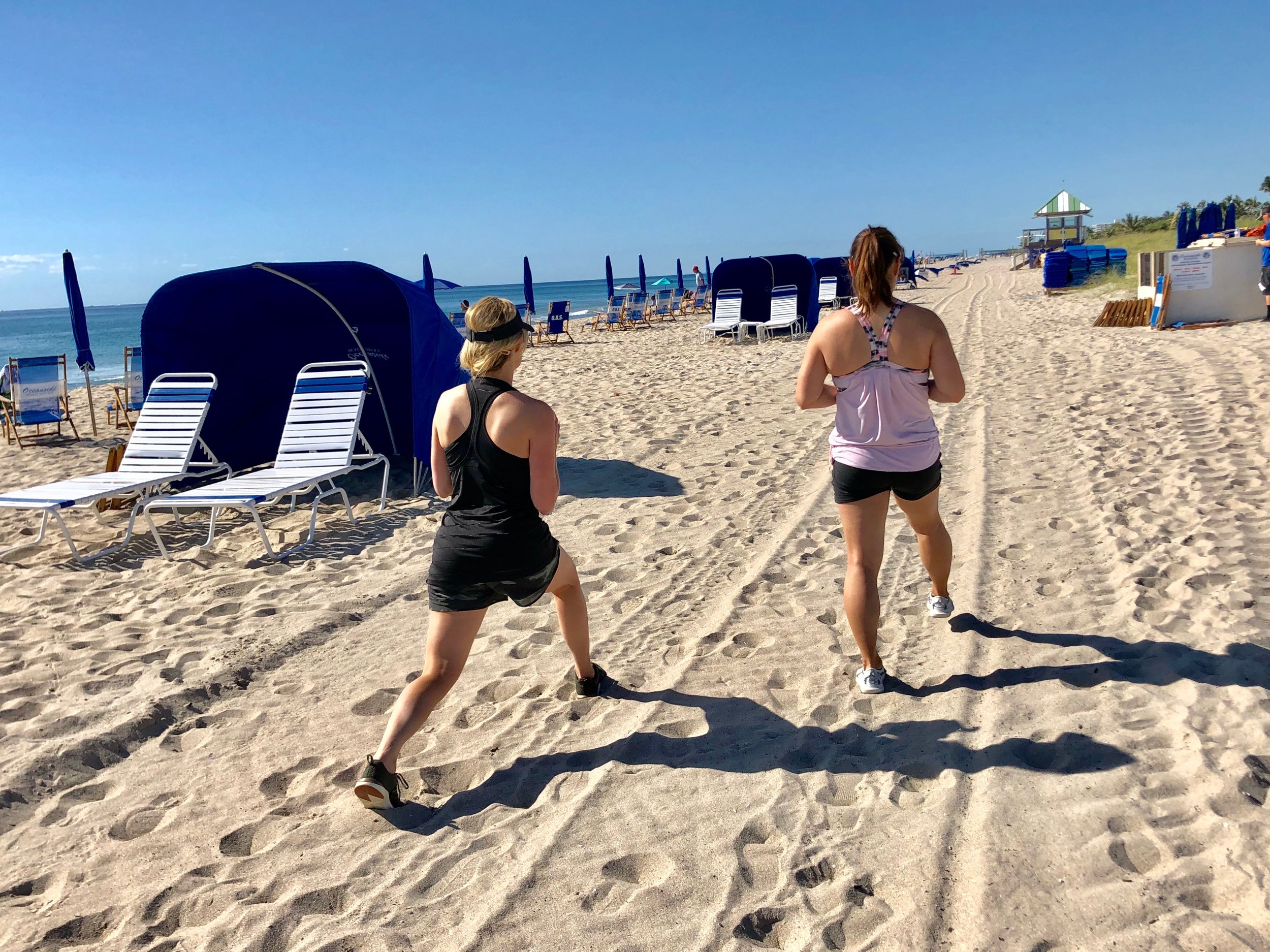 Lunges on beach during fitness retreat.