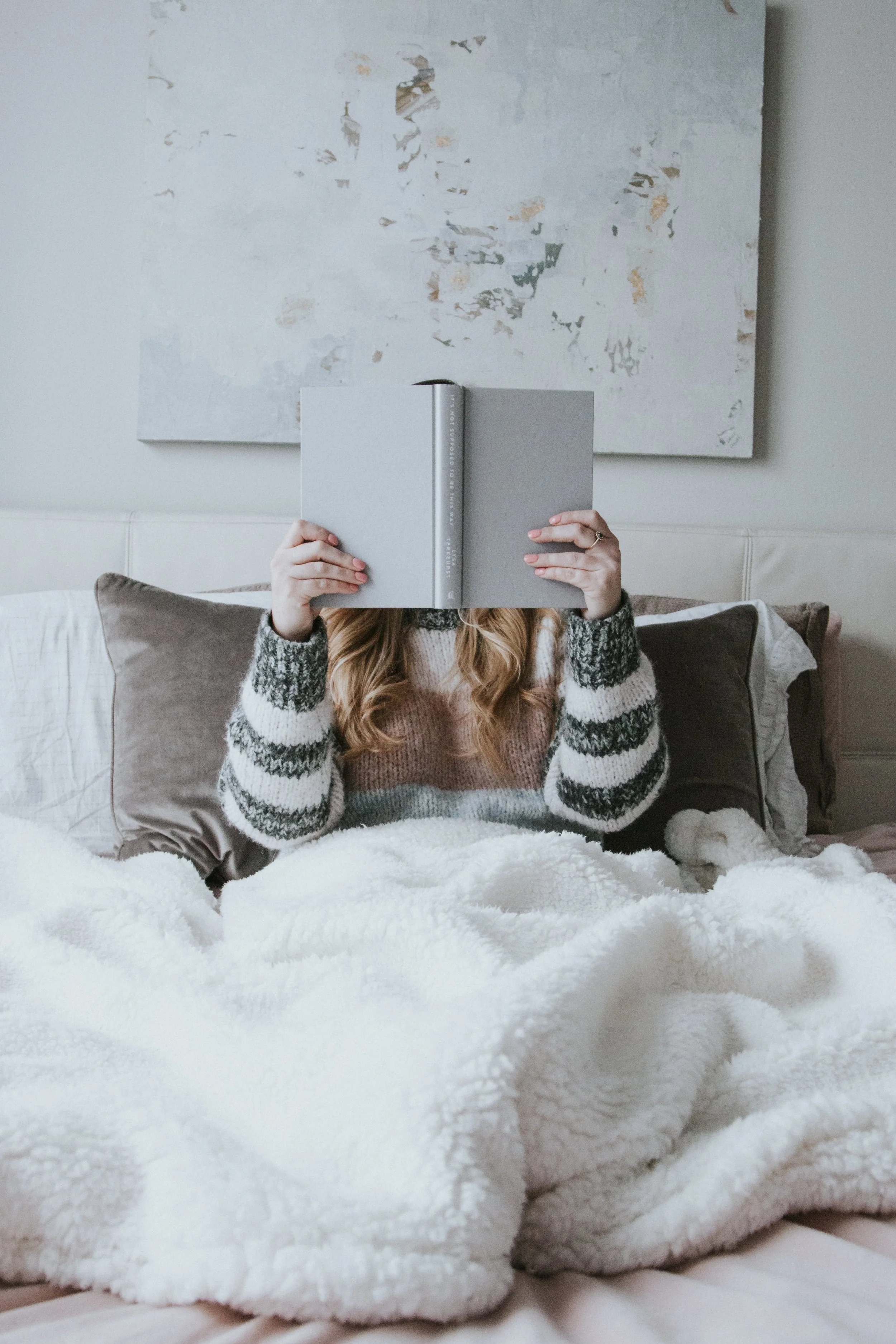 Woman reading before bed for better sleep.