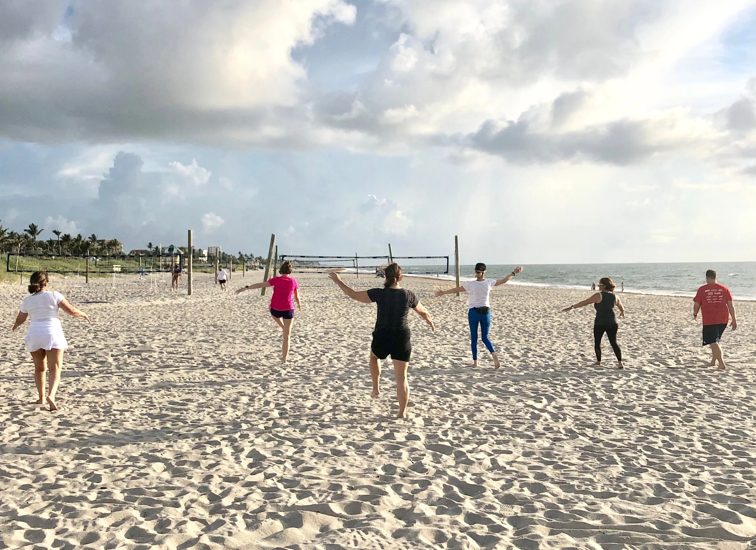 Boot camp guests enjoy a workout on the beach during their vacation.
