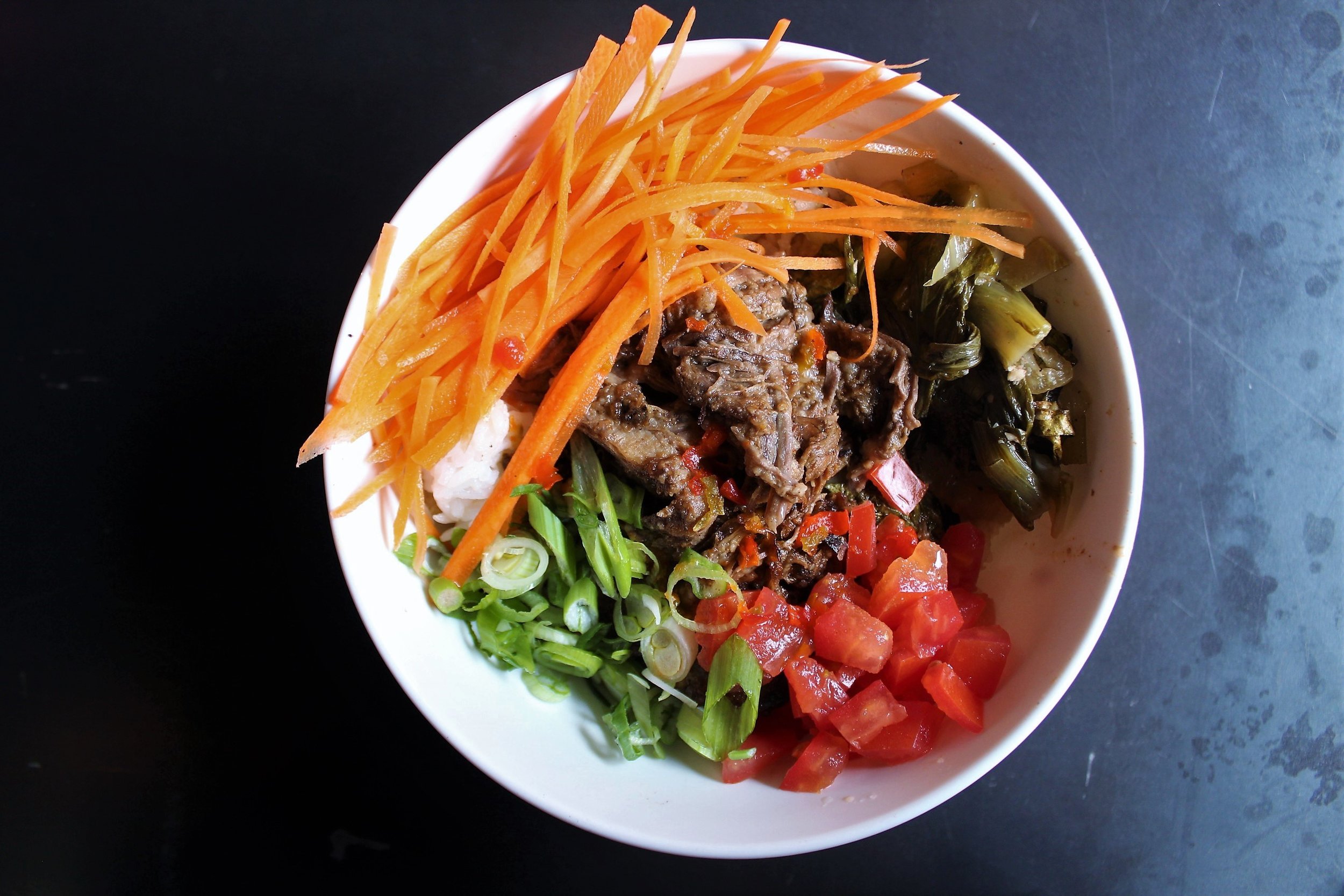 Sinigang Bowl with Short Rib, Garlic Fried Rice, Tomatoes, Carrots, and Bok Choy