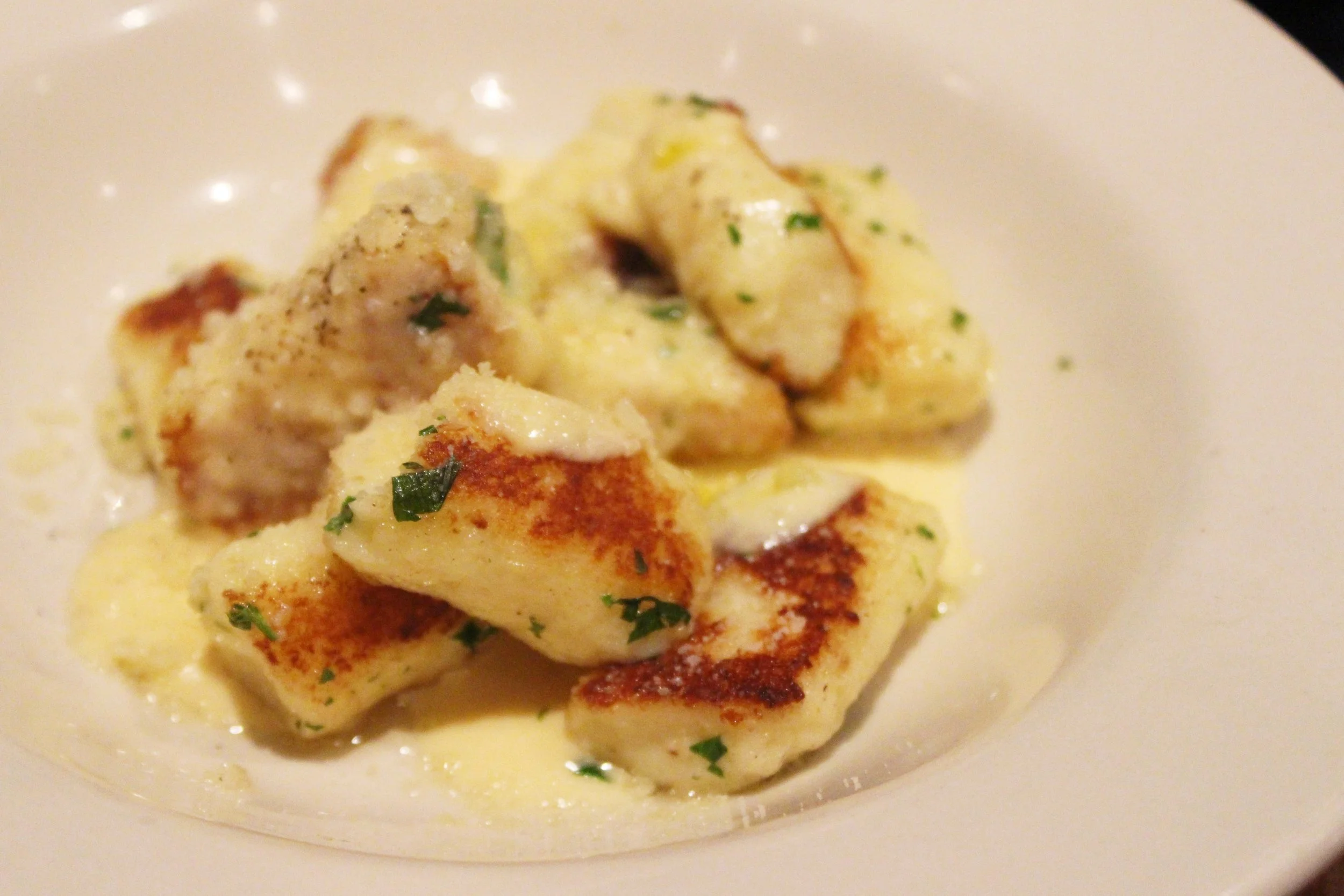 Toasted Ricotta Gnocchi with parmesan, Italian parsley, and white truffle crème