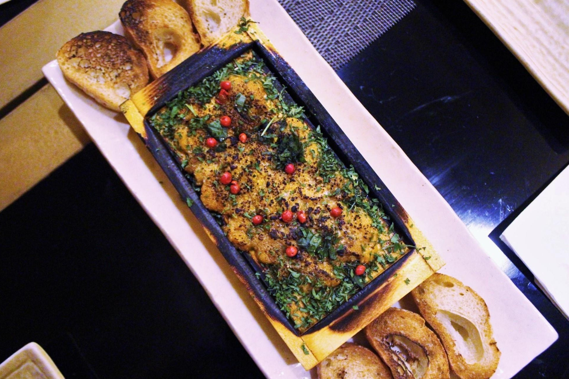 Broiled Sea Urchin with Garlic, Pink Peppercorn, and Shiso