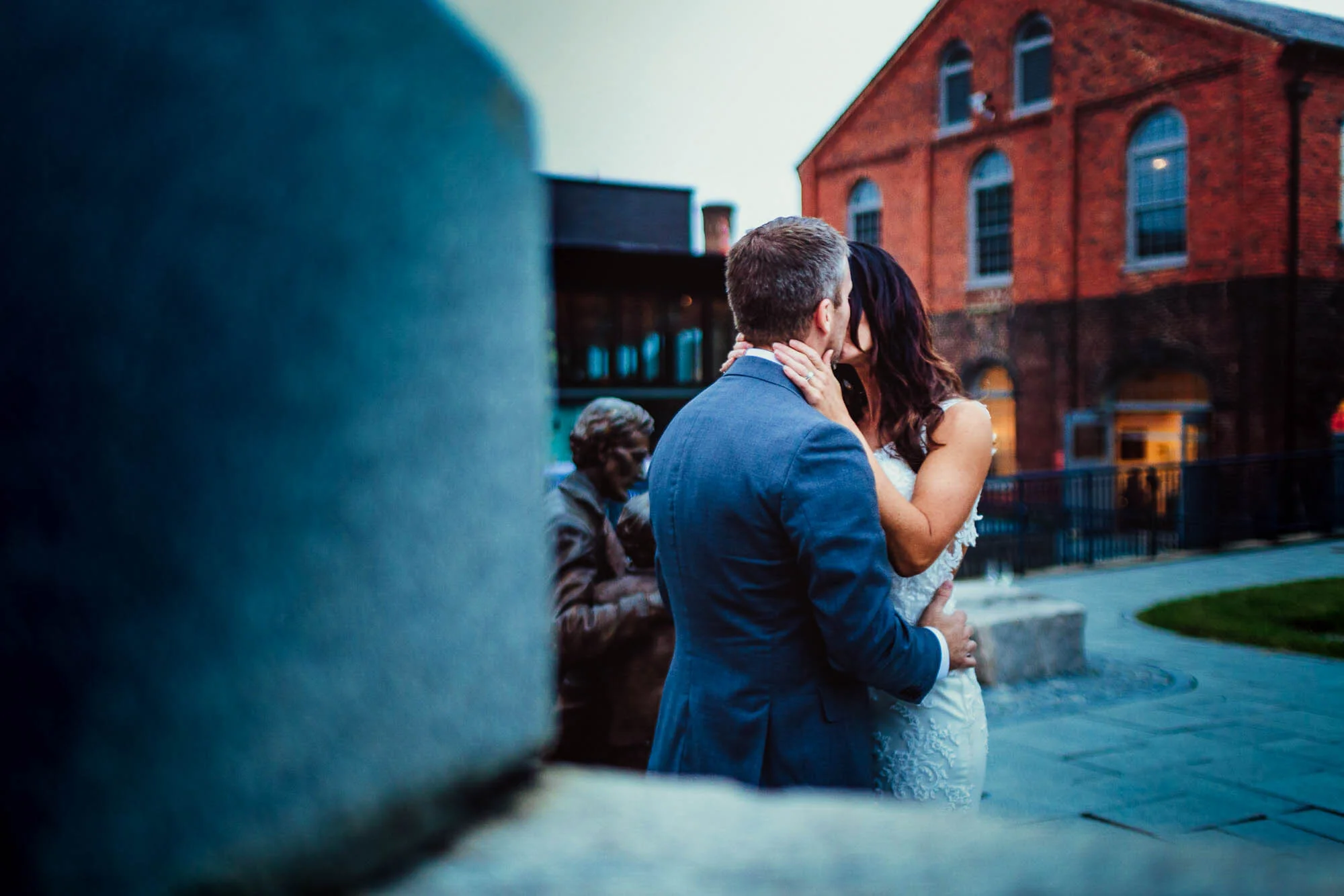 bride and groom kissing behind wall.jpg