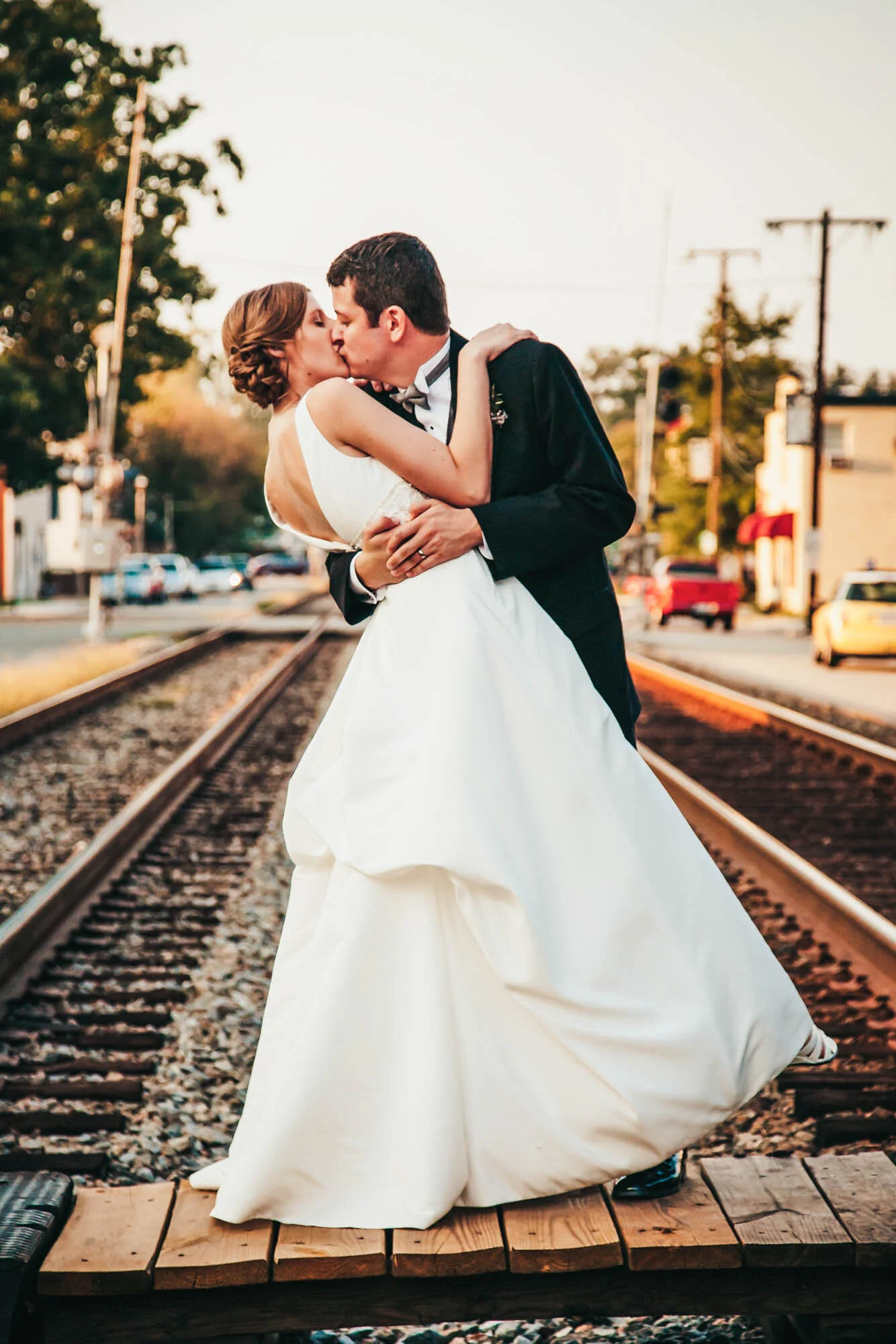 bride and groom kissing on railroad tracks.jpg