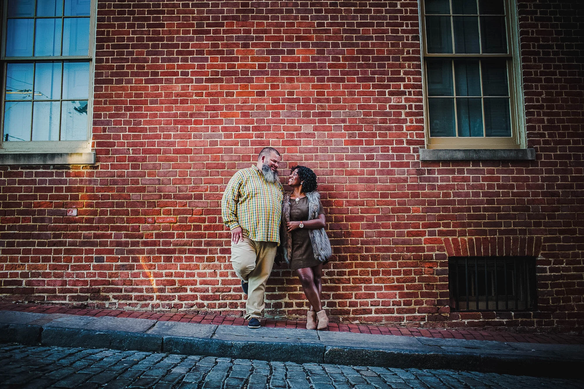 couple standing before brick wall.jpg