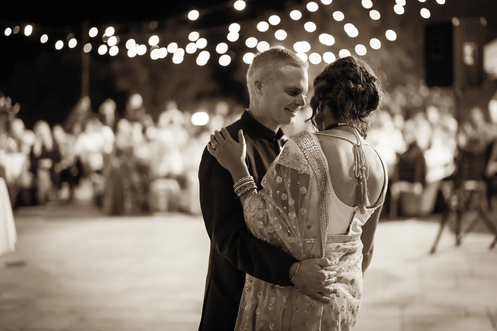Wedding couple dancing under winery lights